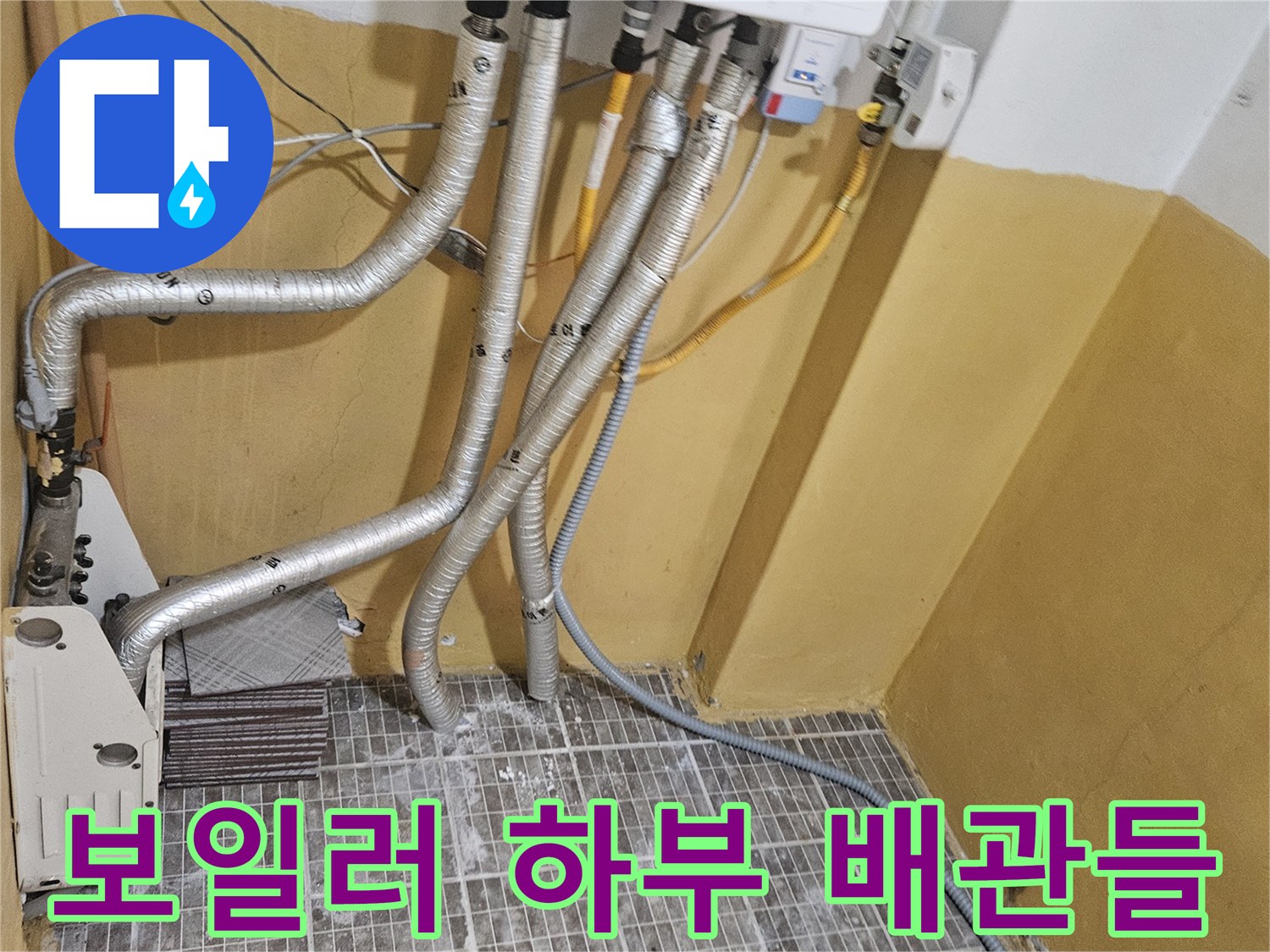 보일러 아래쪽으로 뻗어 있는 은색 보온재 배관들의 모습