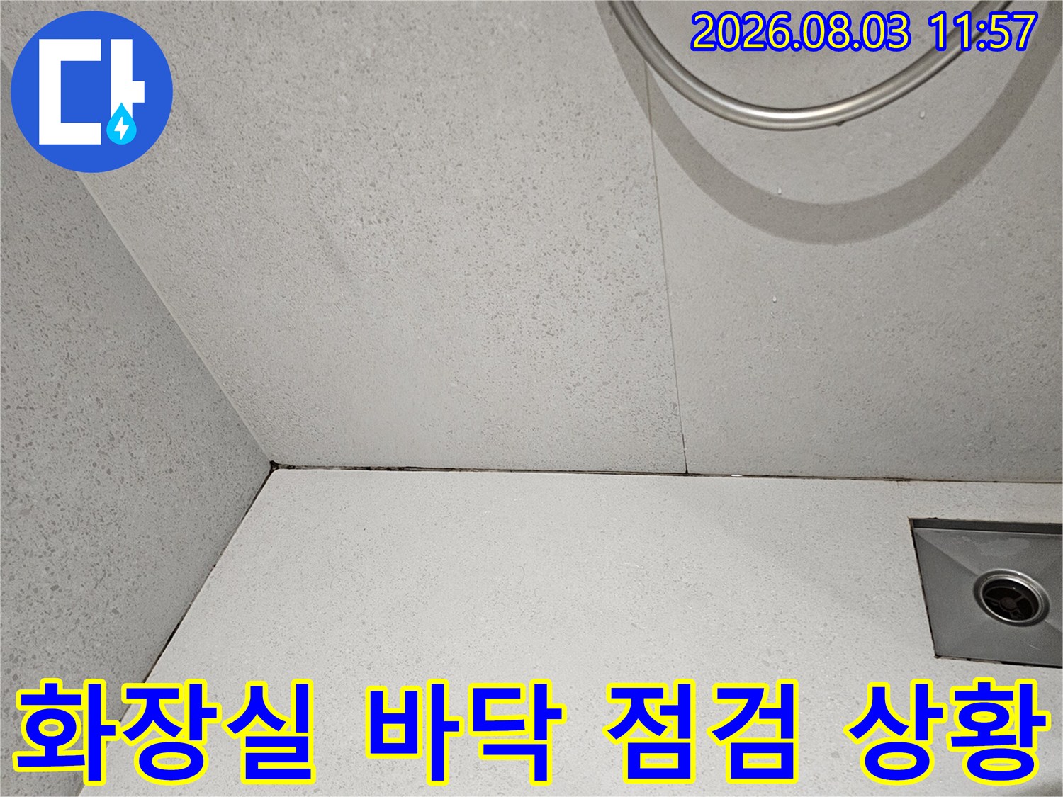 배수 트랩 주변의 타일 마감과 균열 상태를 촬영한 이미지