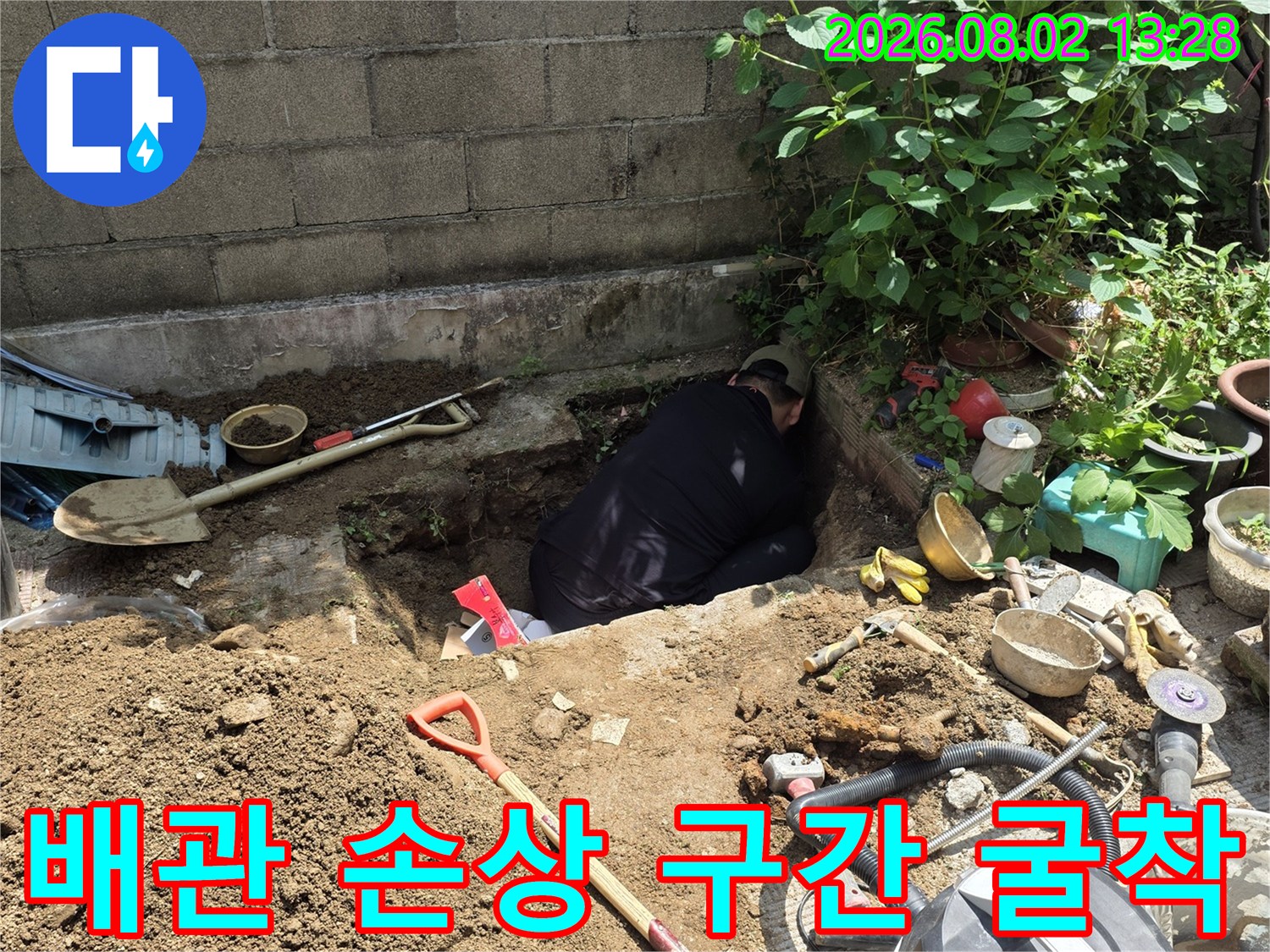 장비와 삽이 놓인 흙을 파낸 배관 공사 현장 사진