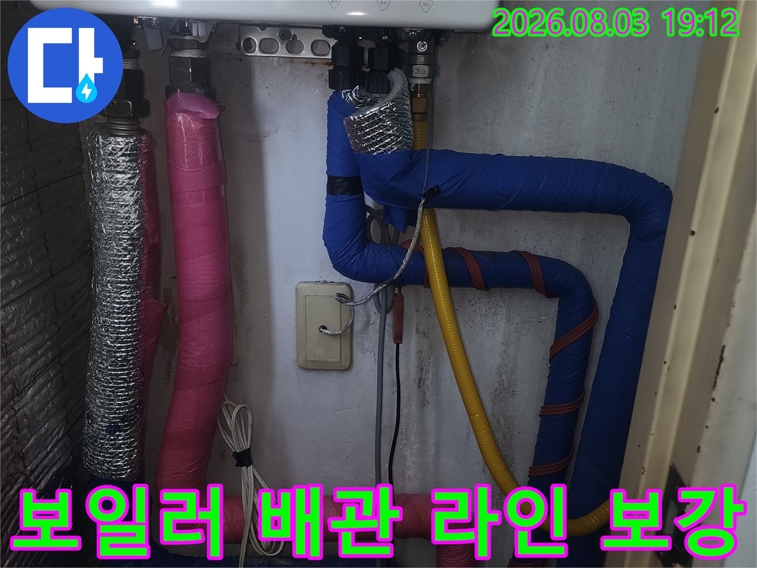분홍색과 파란색 단열재로 꼼꼼하게 마감된 보일러 시스템 배관