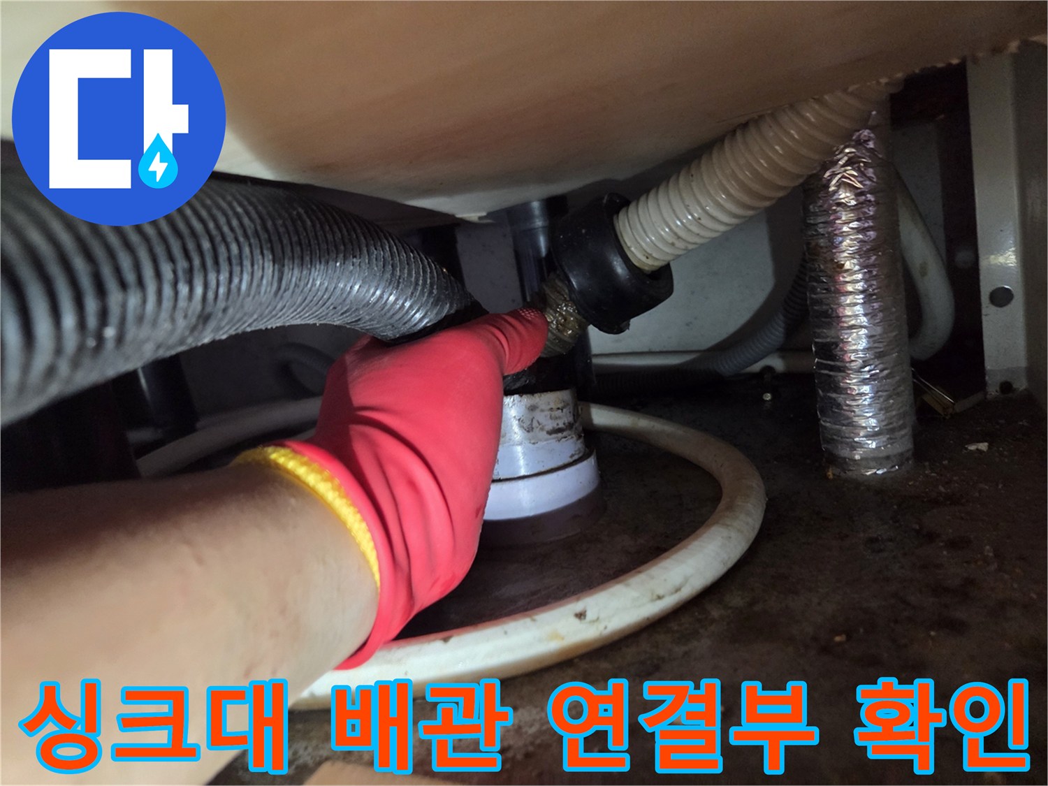 싱크대 하단 배수 호스 연결 부위를 점검하는 엔지니어 작업 장면