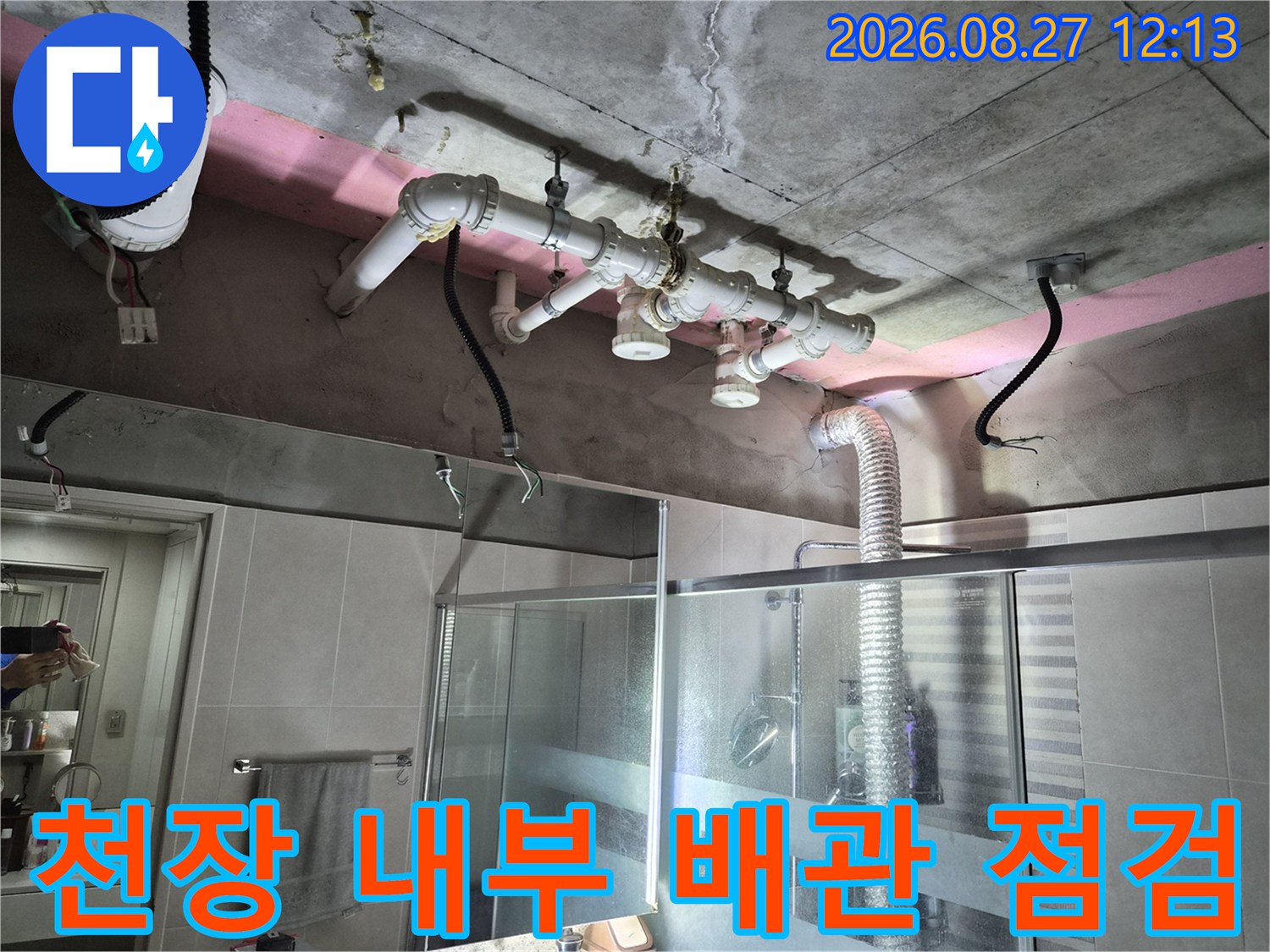 욕실 천장 안쪽의 하수 배관과 콘크리트 슬라브의 상태를 보여주는 사진입니다.