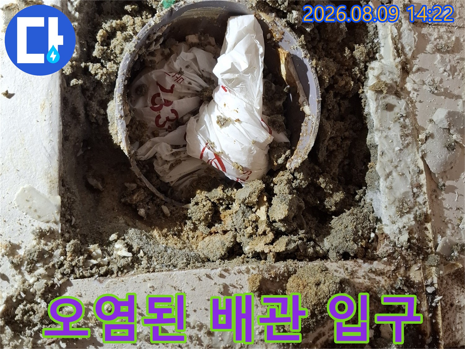 오수관 주변의 젖은 모래와 이물질이 섞인 모습