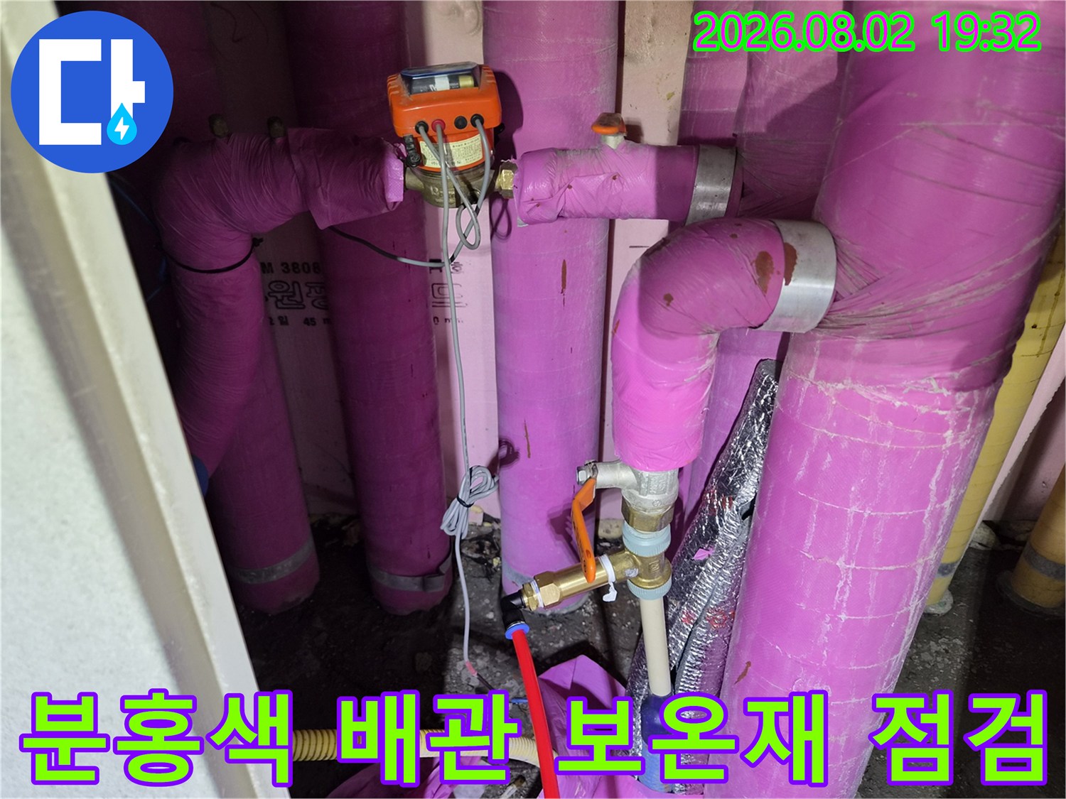 분홍색과 파란색 보온재로 감싸진 에어컨 배관 시스템을 점검하는 모습