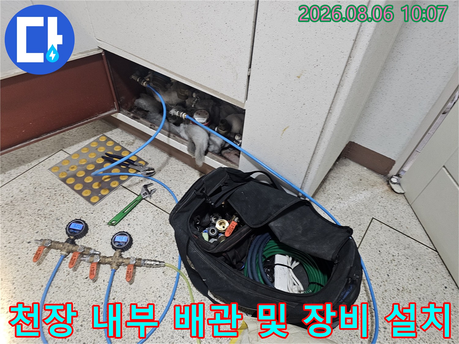 누수 탐지를 위해 연결된 파란색 호스와 전문 계측기