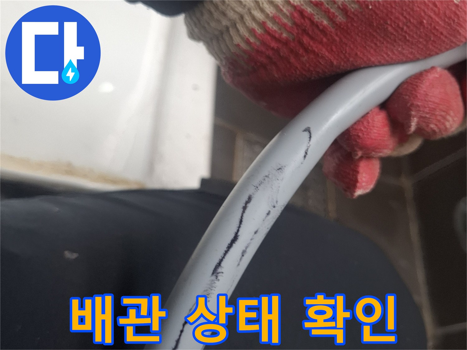 작업자가 손으로 배관의 외관을 살피는 모습