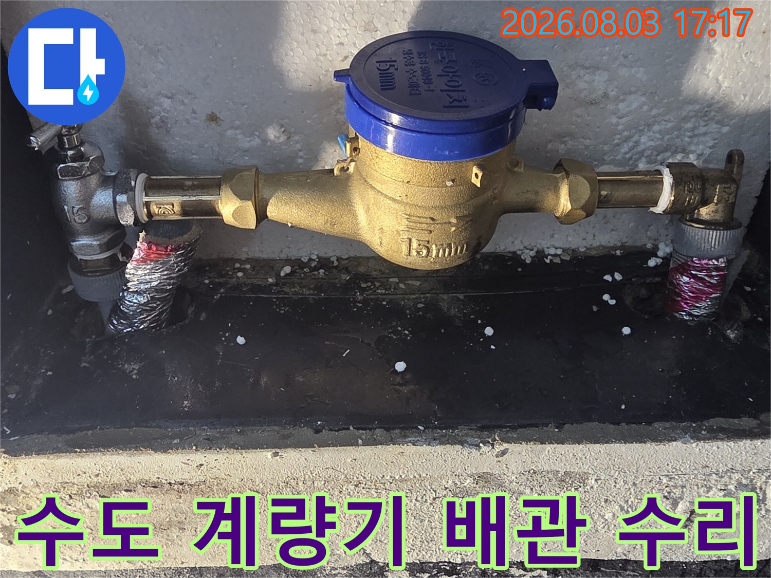 금속 배관과 파란색 계량기가 결합된 공사 현장 사진