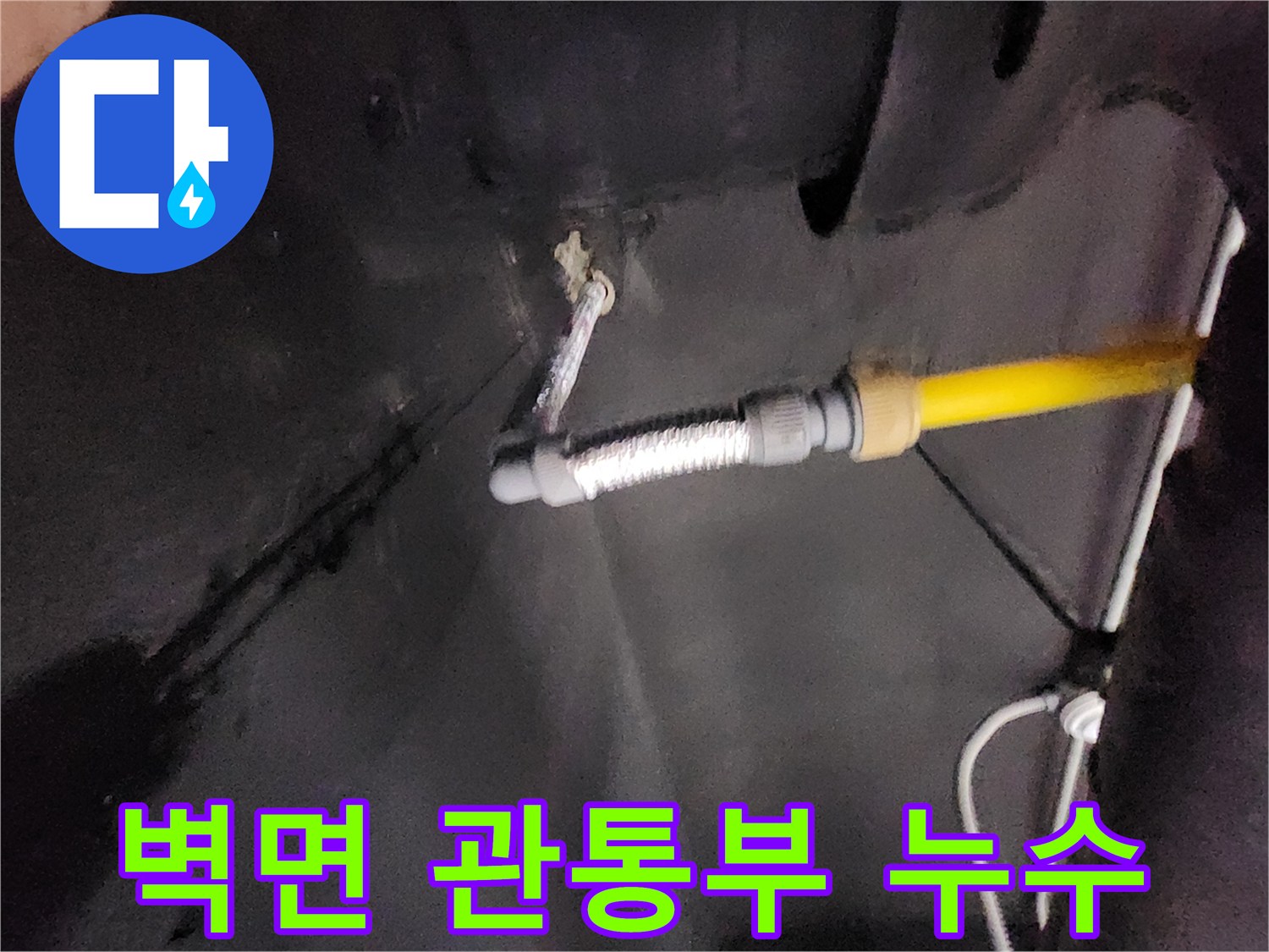 습기가 번져있는 벽면과 노란색 및 은색 배관의 모습