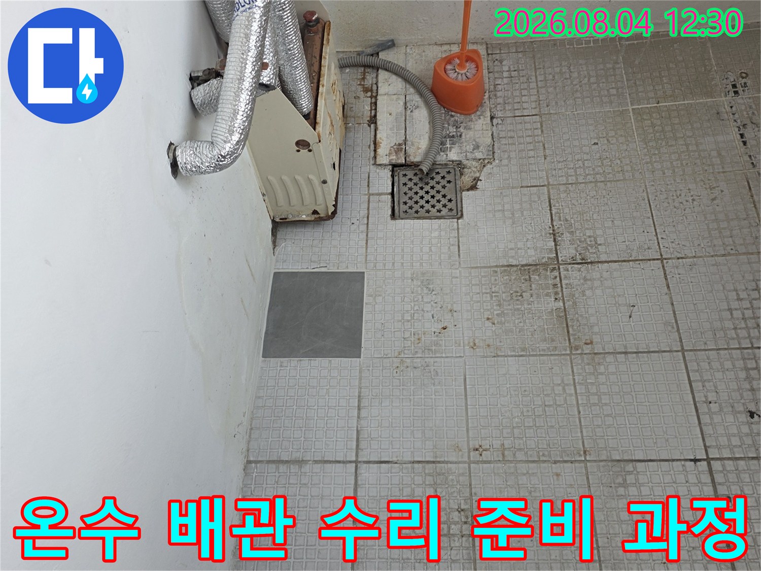 타일 파손 구간 내 노출된 온수 배관과 전문 도구들