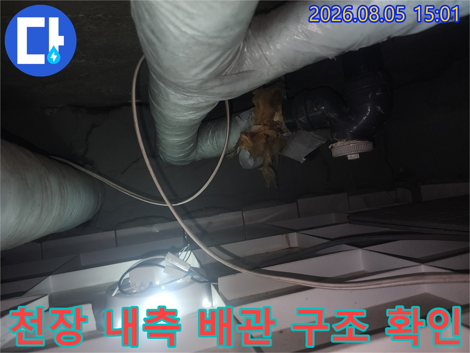 보온재로 덮인 천장 안쪽 배관의 연결부 상태 점검