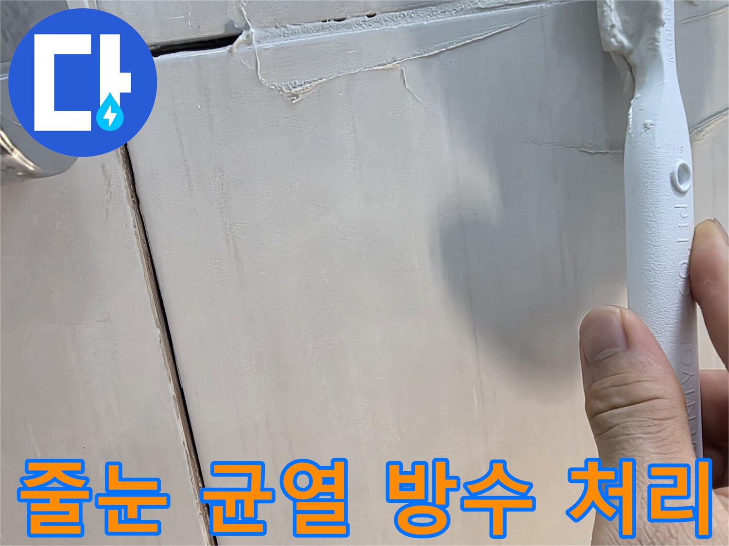 타일 사이의 벌어진 틈에 흰색 보수재를 채워 넣는 모습