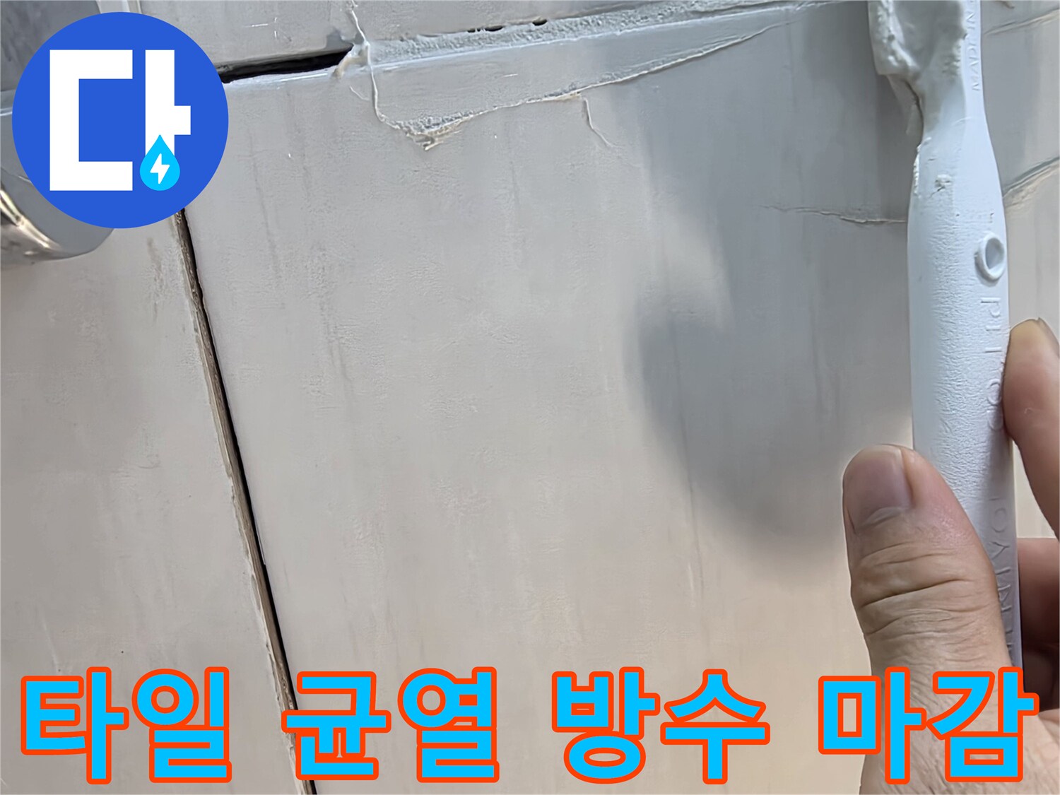 화장실 타일 사이 벌어진 틈에 하얀 충진재를 넣는 과정