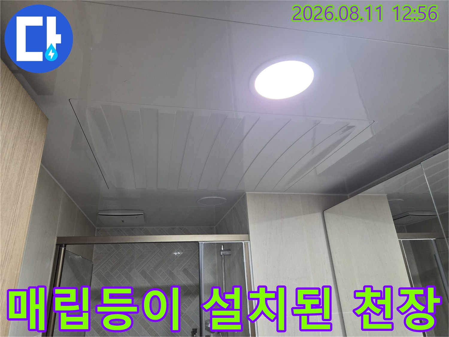밝은 조명이 켜진 화장실 천장 마감재 시공 완료 사진입니다.