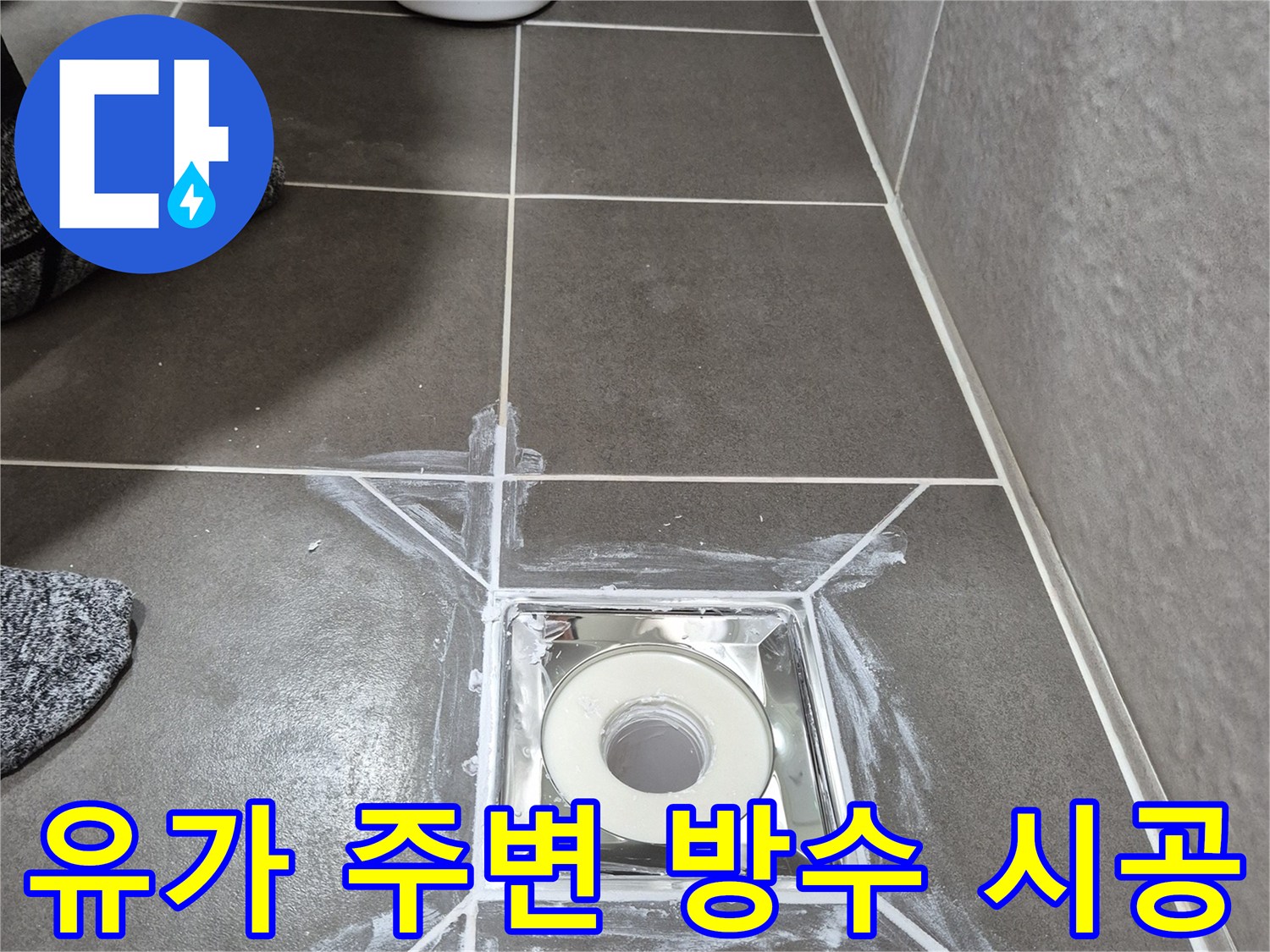 배수구 유가-주변 타일 접합부에 흰색 방수재를 도포한 상태