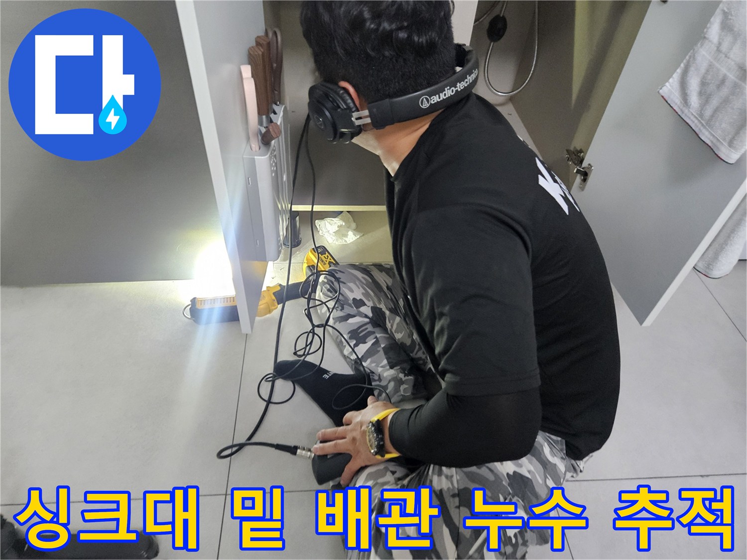 청음기를-사용해-싱크대-하부장-내부의-미세한-누수를-찾는-모습