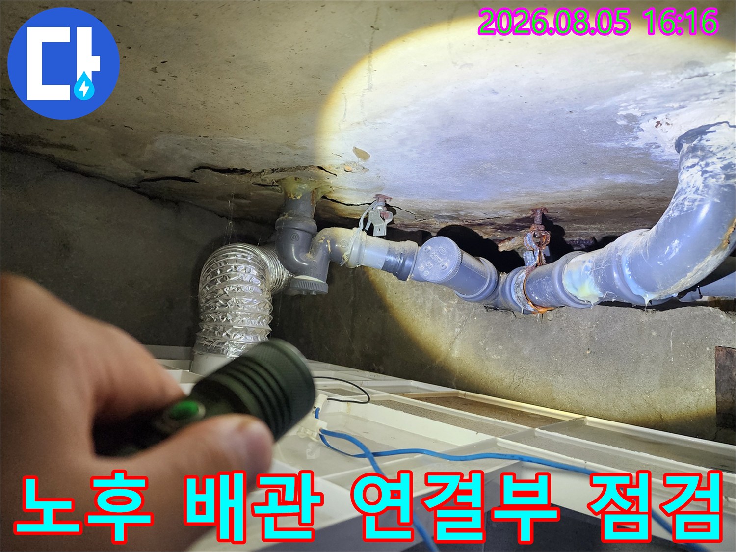 조명으로 비춘 화장실 내 노출된 천장 배관망