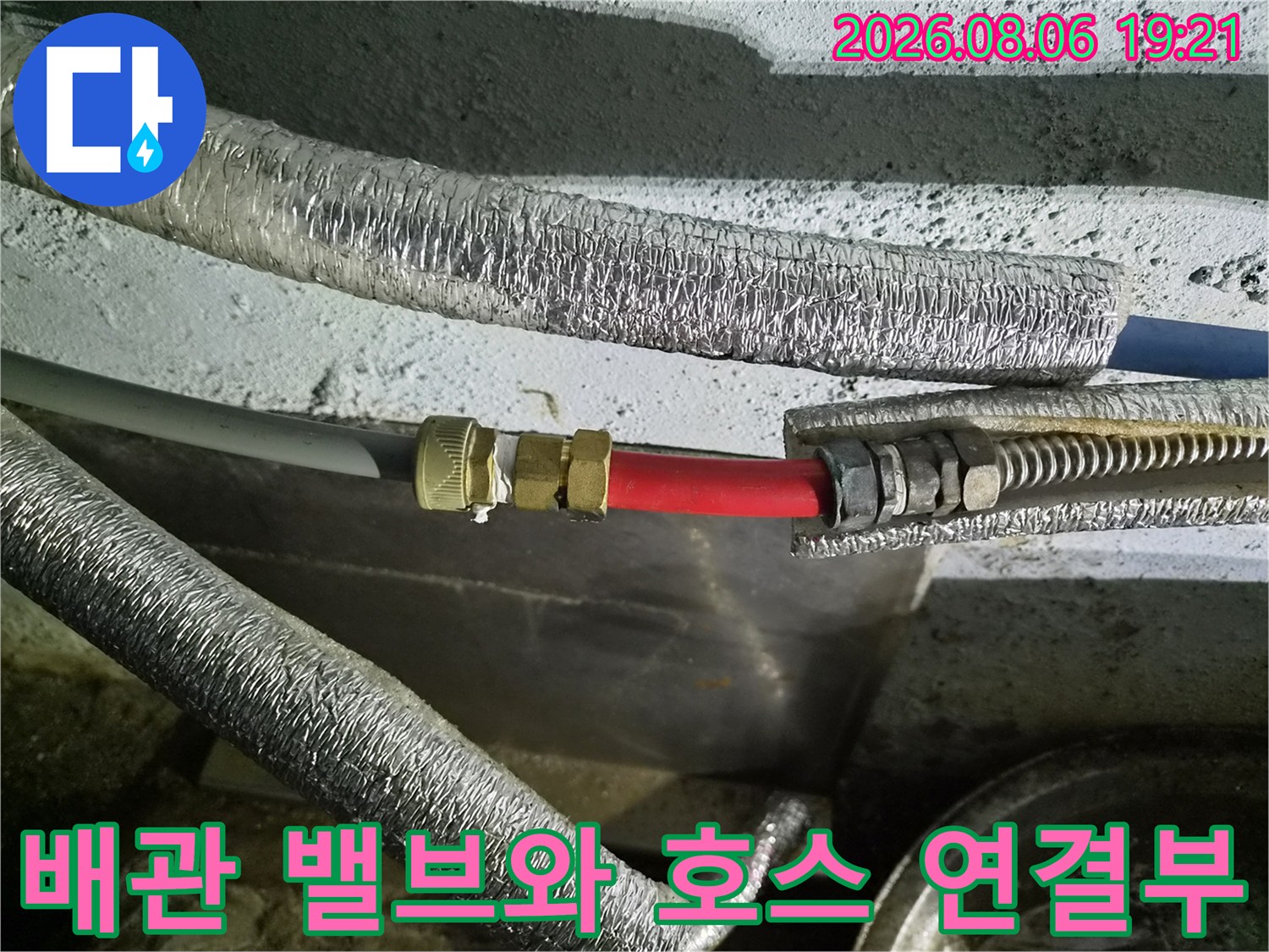 단열재로 감싼 배관과 노출된 빨간색 호스의 결합 구조