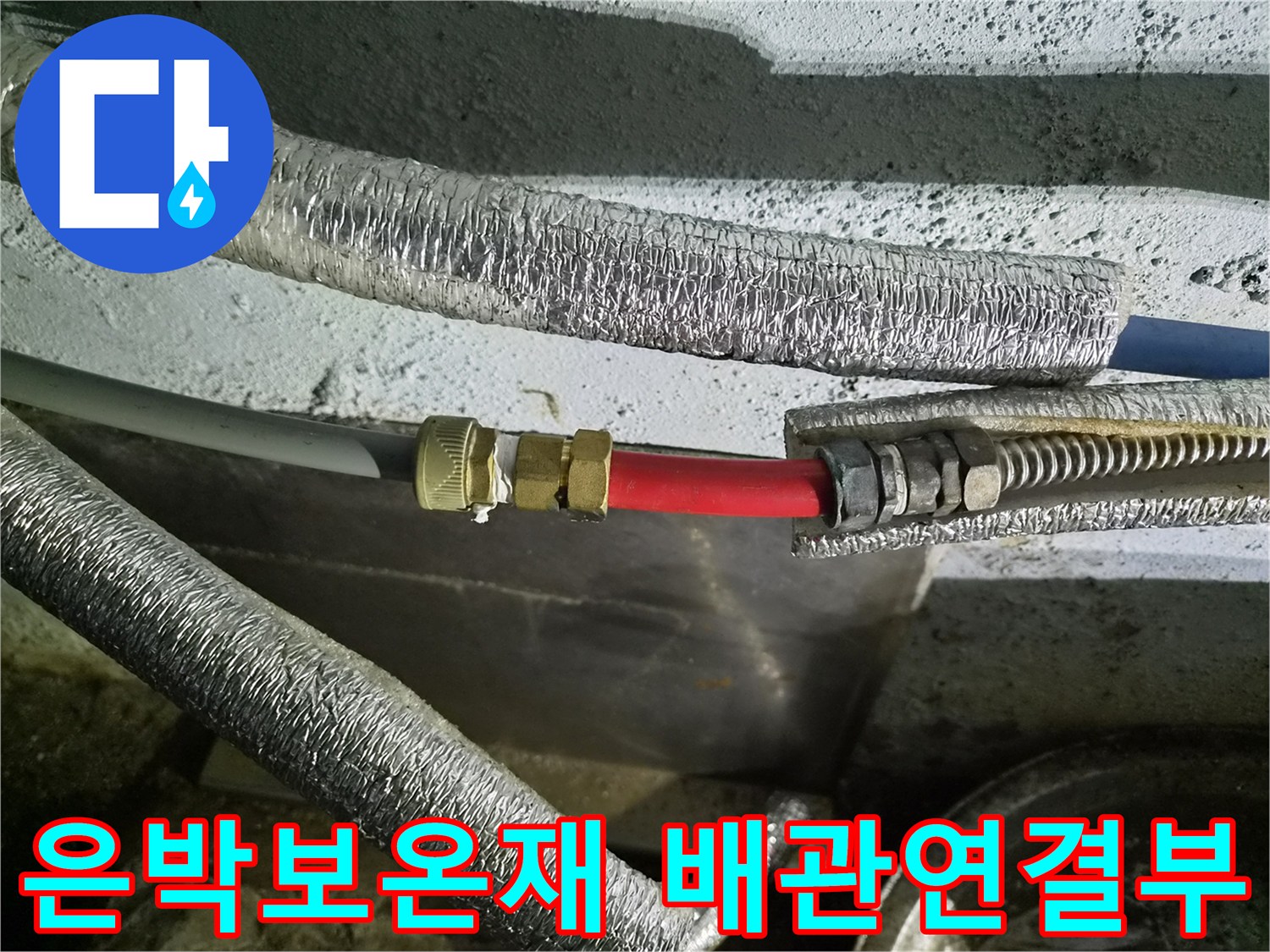 은박 보온재로 감싸진 수도 배관의 연결 부위 모습입니다.