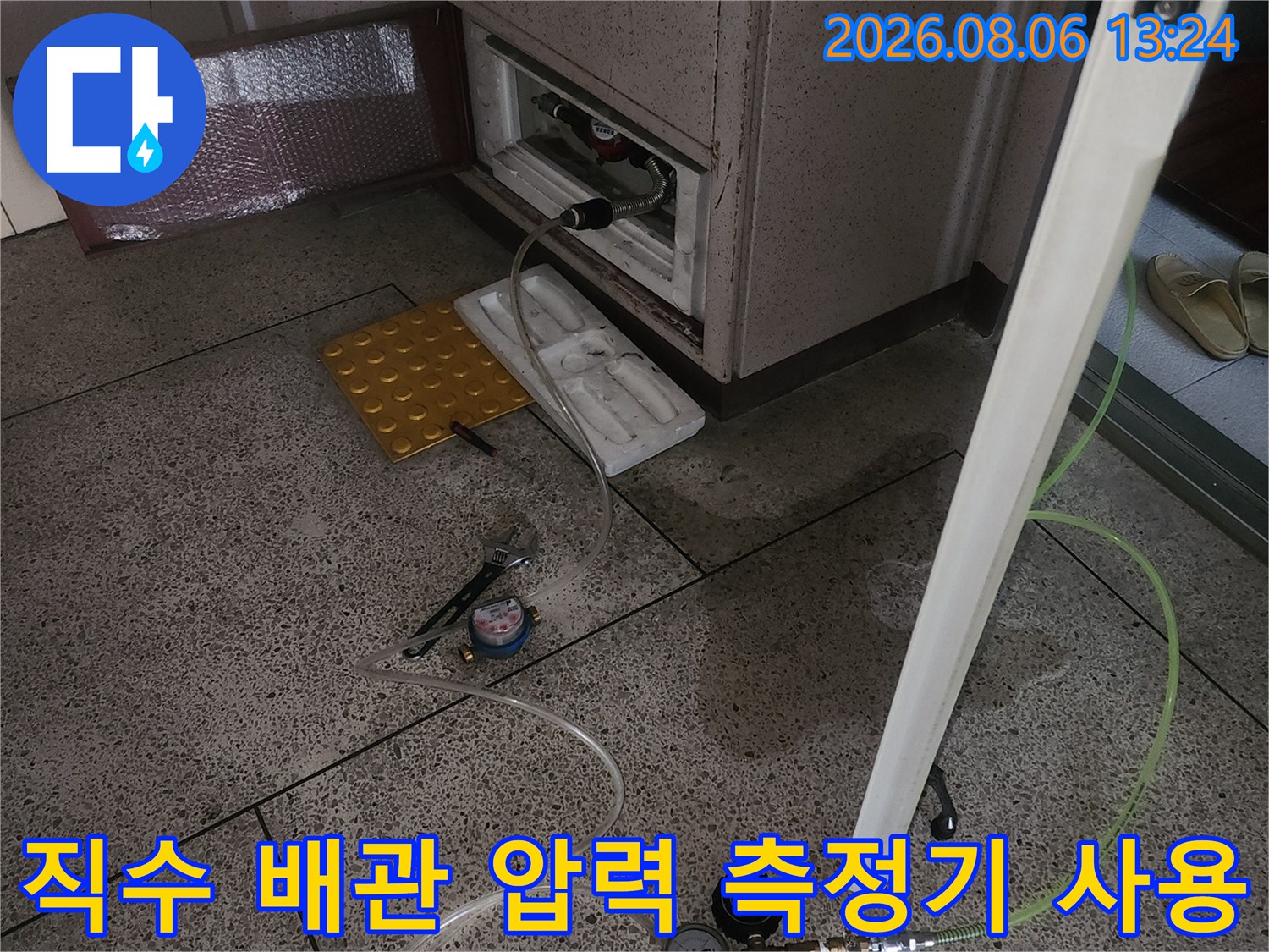 배관의 이상 여부를 판별하기 위해 압력계와 호스를 연결한 장면