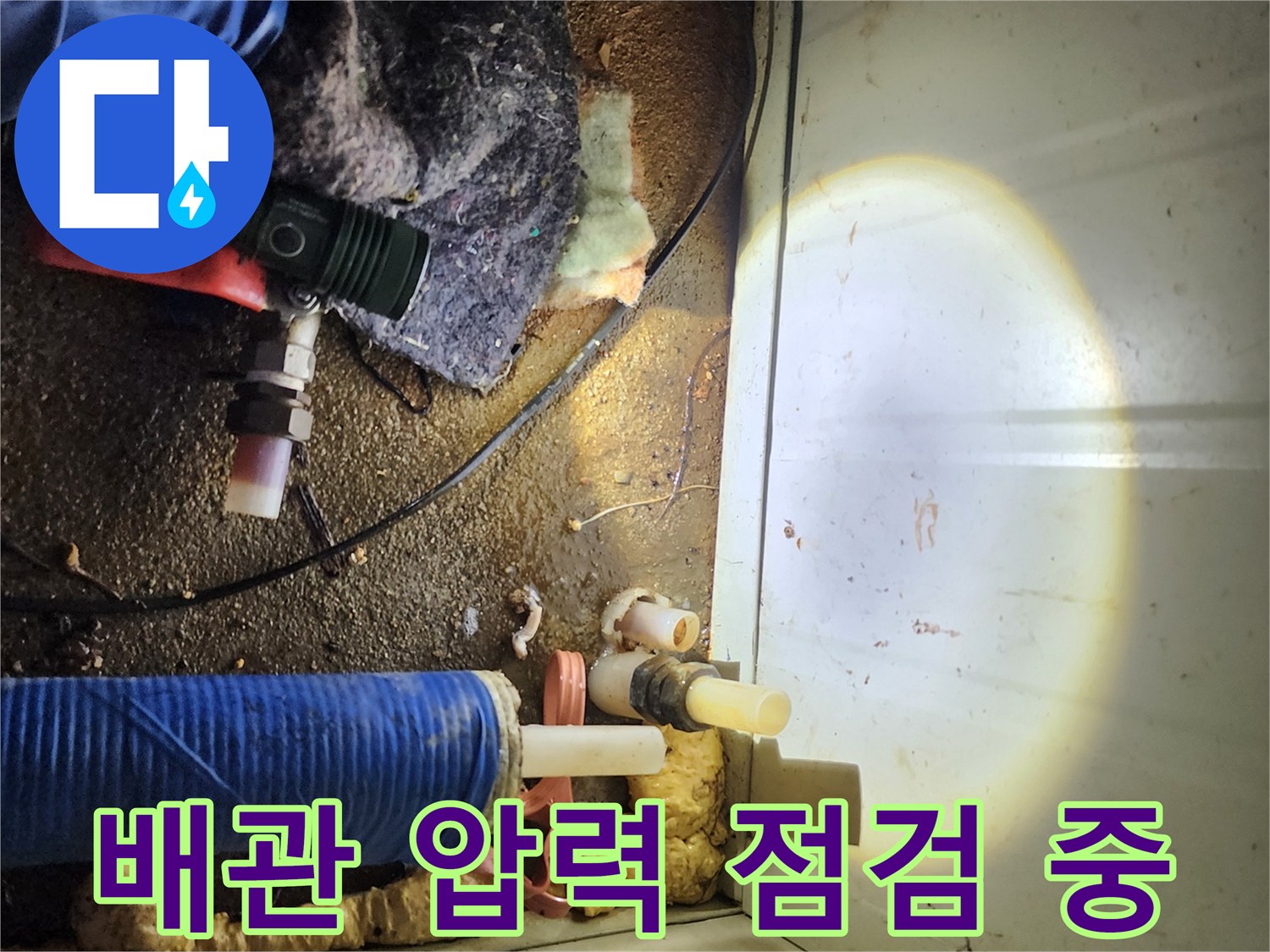 누수 지점 추적을 위해-배관 주변을 살피는 모습