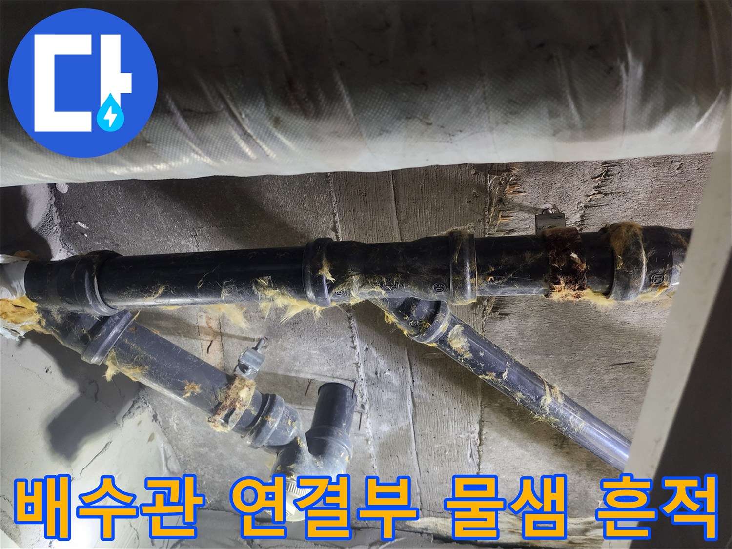 축축하게 젖은 검정색 하수 배관의 연결 부위와 오염물질