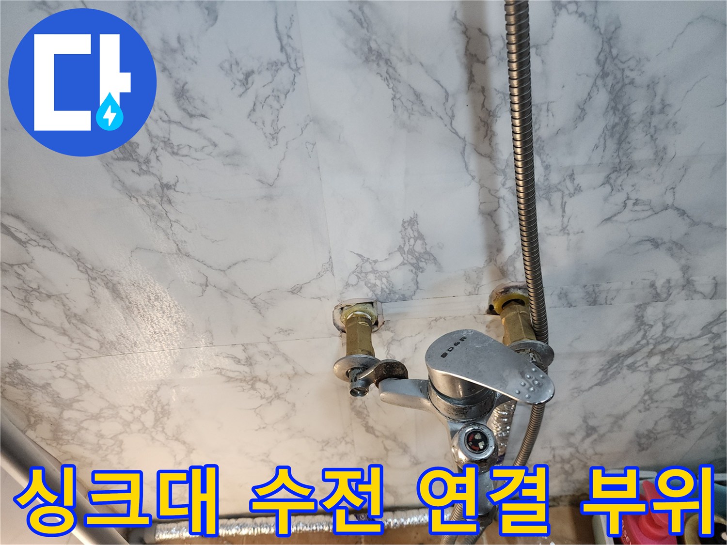 벽면 밸브와 연결된 주방 수전 하단부 근접 촬영