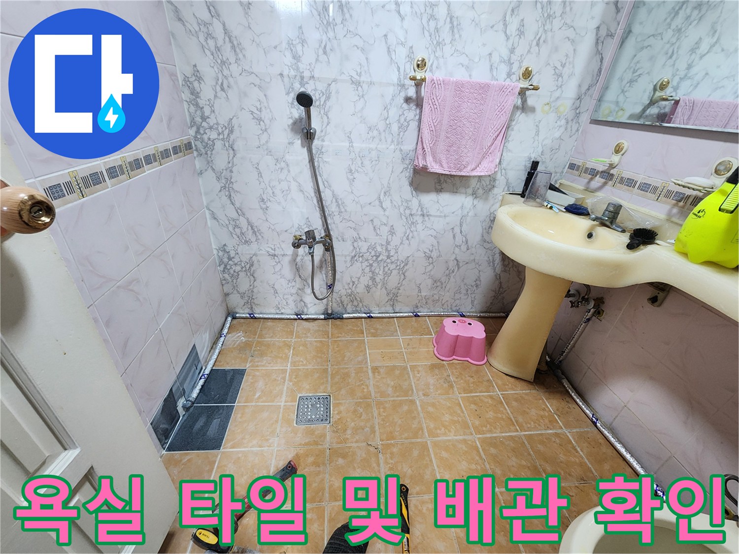세면대 하부의 수전과 바닥 배수구 주변을 점검하는 현장 사진