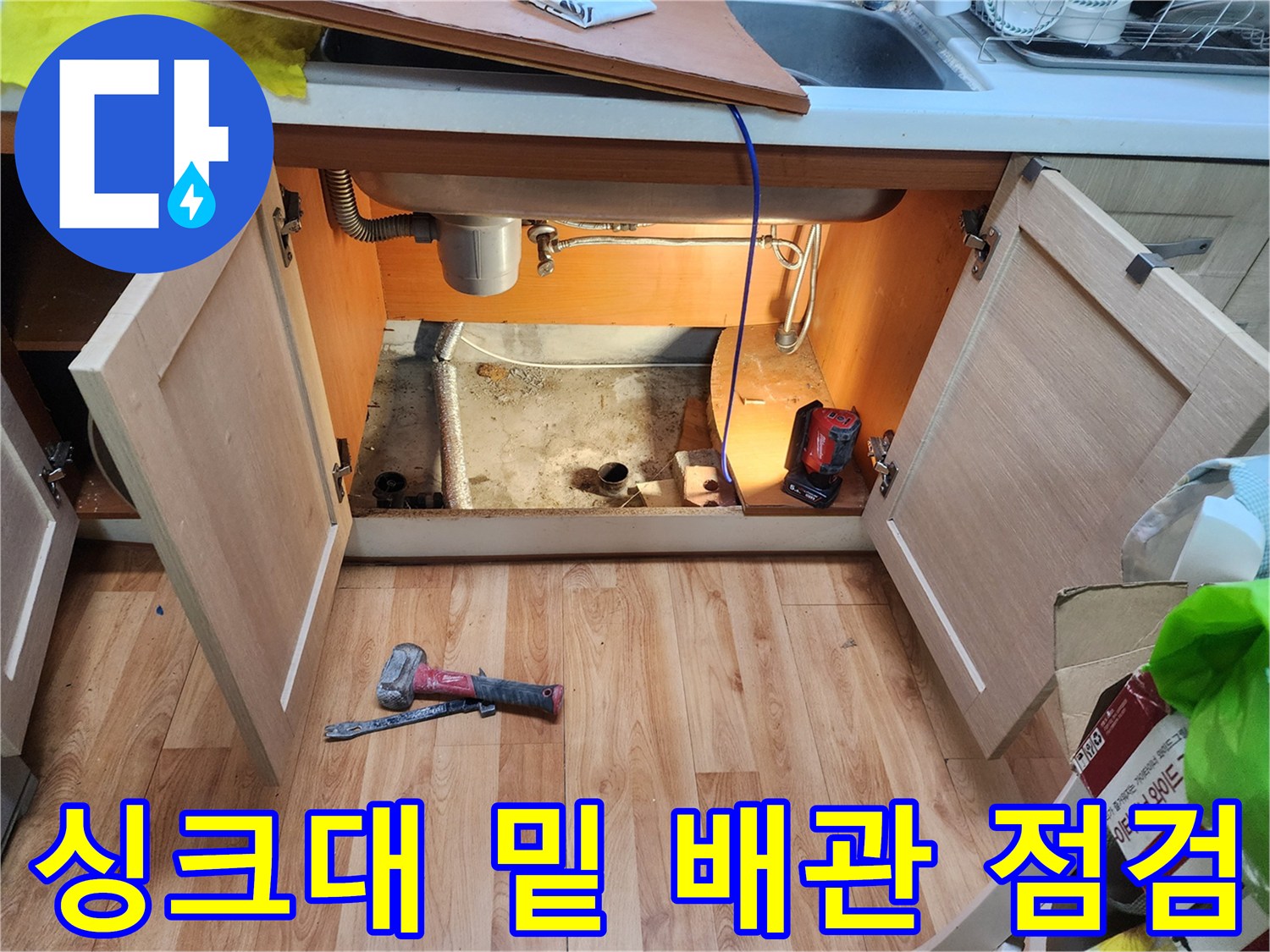싱크대 아래쪽 하부장 내부의 배수 호스 및 바닥 배관