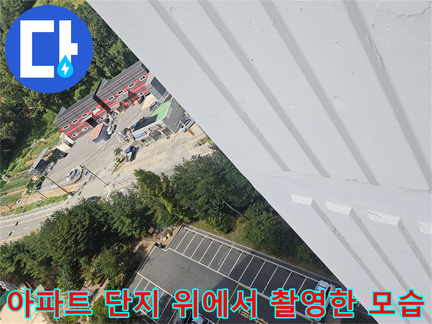 높은 층 건물에서 바라본 아파트 주차장과 도로 전경