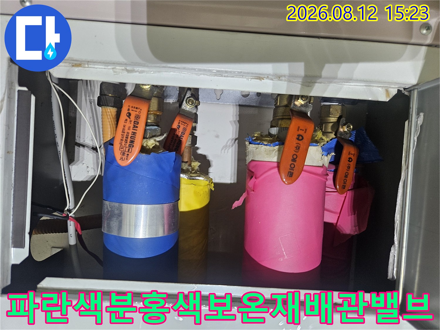 아파트-내부-함속에-위치한-파란색과-분홍색-보온재로-감싸진-수도-배관-밸브들