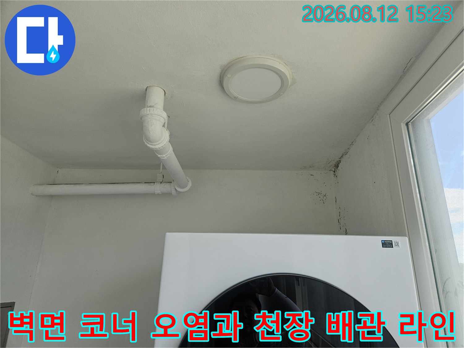 흰색 천장 조명과 배관 그리고 벽면 모서리에 핀 검은 곰팡이-누수 피해 현장