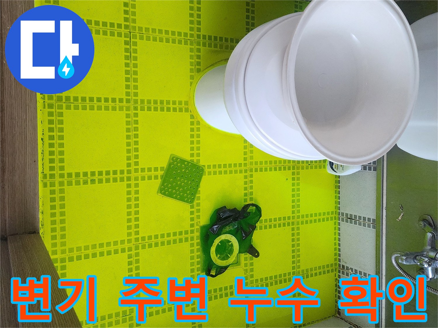 노란색 염료가 뿌려진 화장실 바닥과 변기 하부 모습