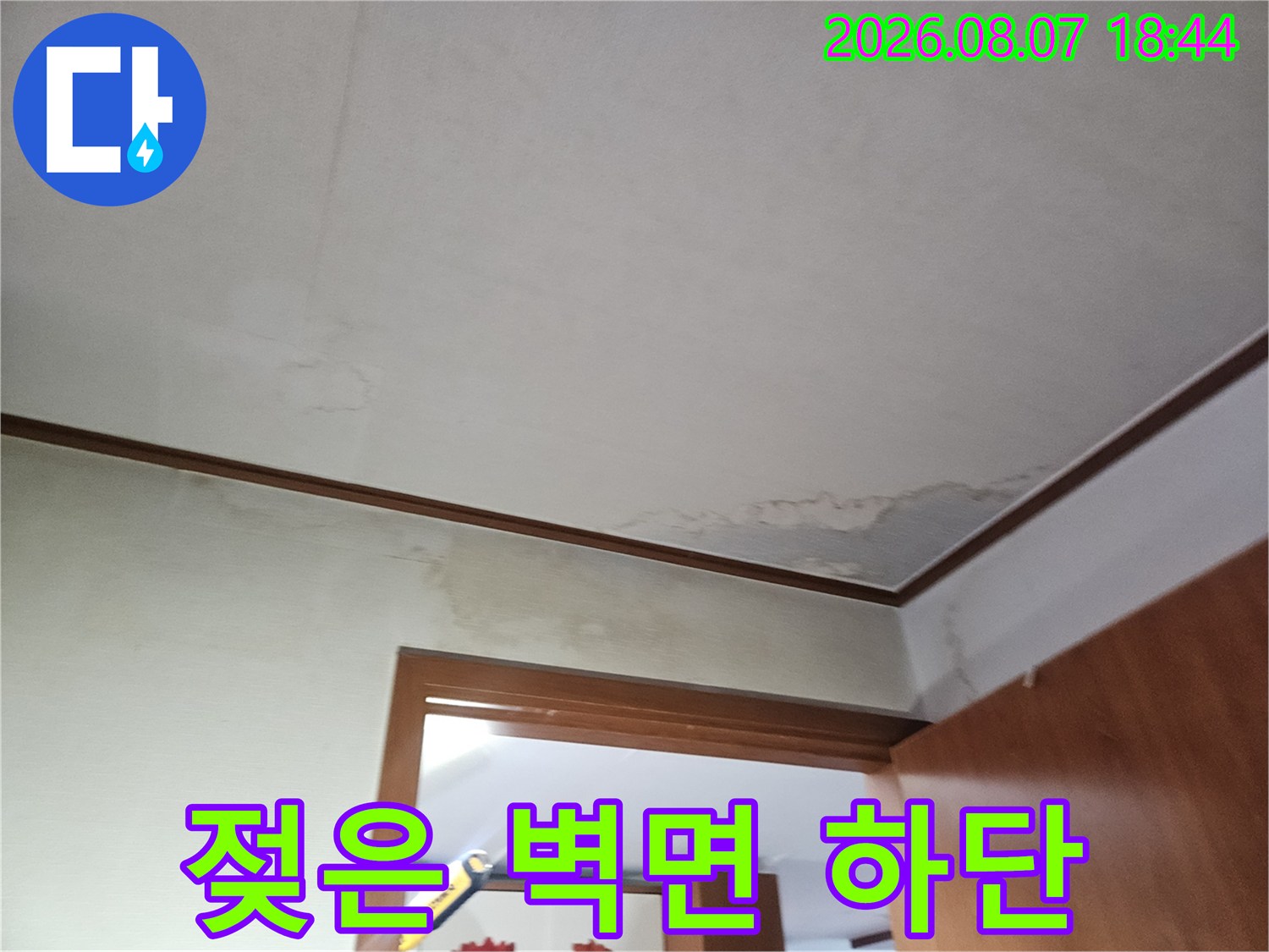 벽지와 문틀 경계 부근에 나타난 누수 침투 흔적