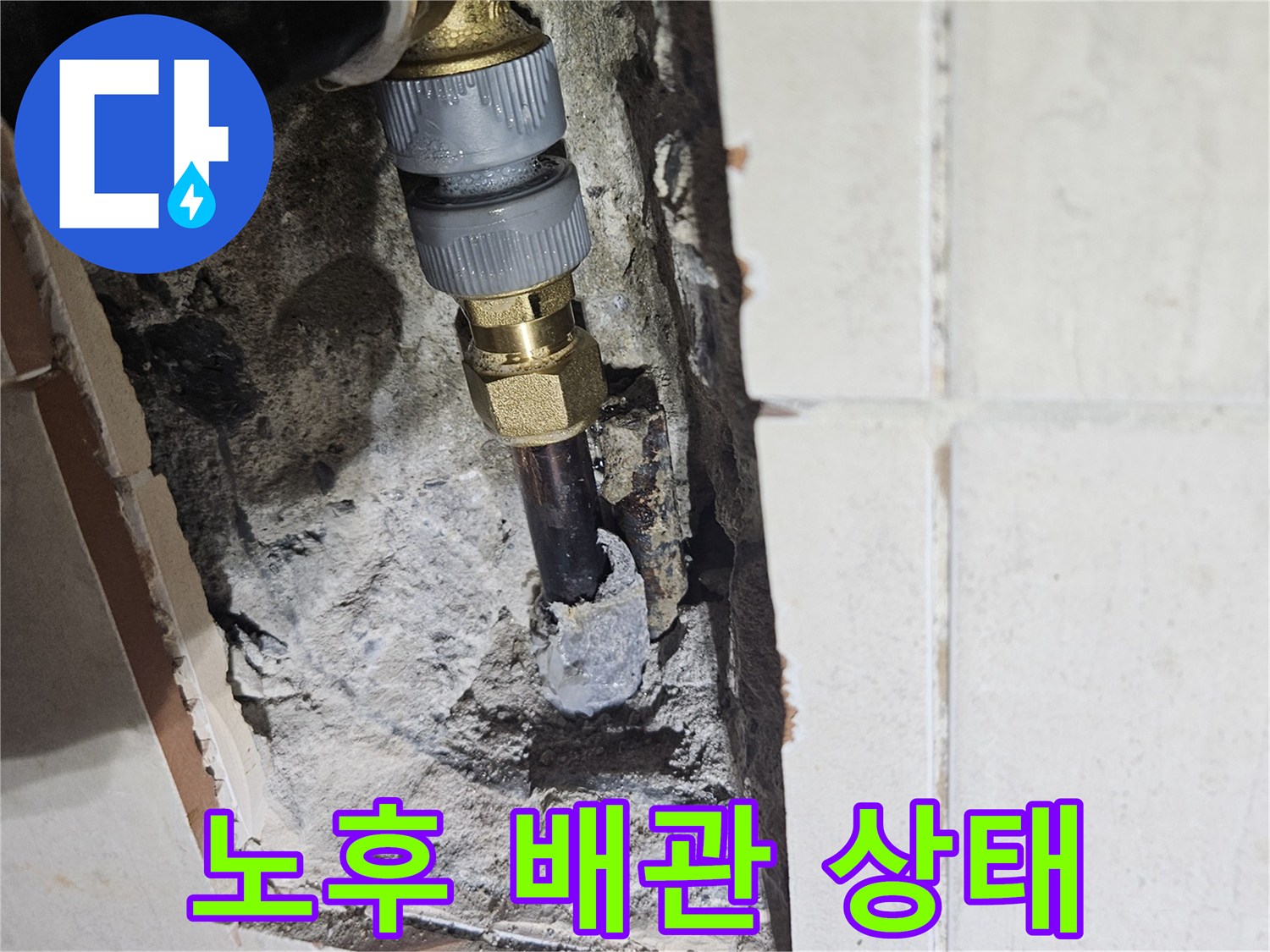 부식된 금속 배관과 연결 부품이 노출된 굴착 현장 사진입니다.