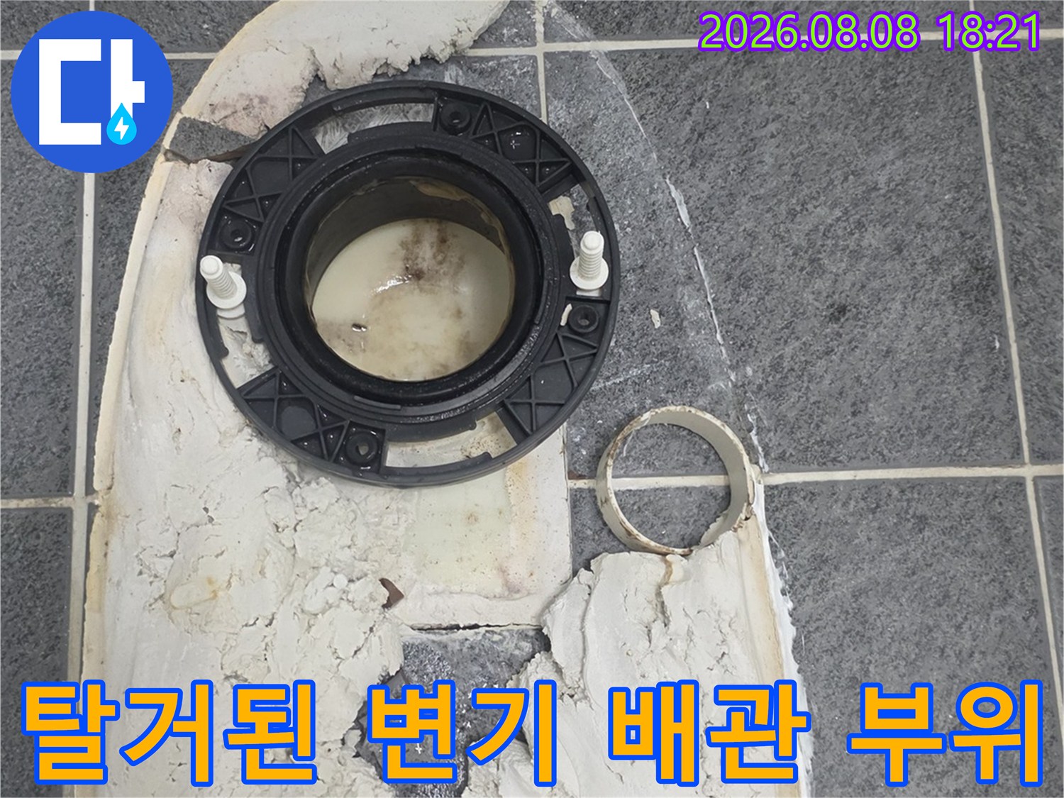 변기 탈거 후 드러난 오염된 하수구 배관과 주변 타일