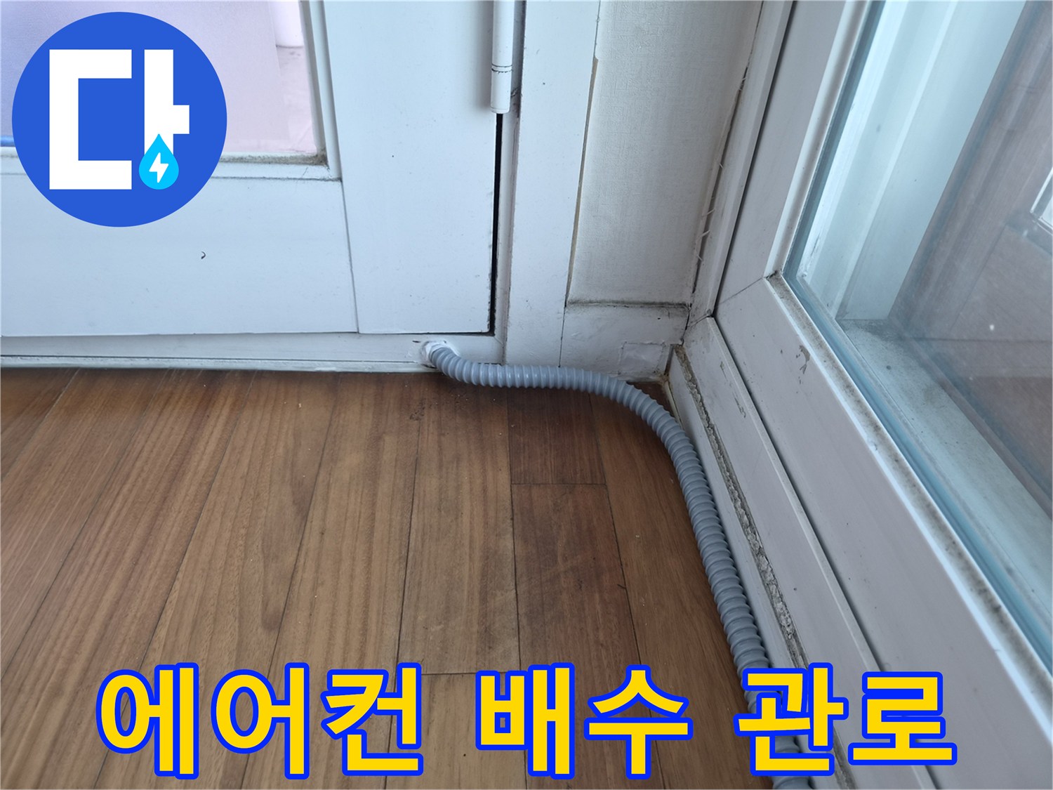 창틀 틈새로 이어지는 회색 주름관