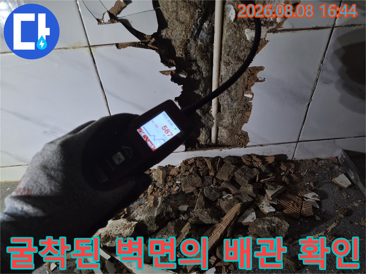 파헤쳐진 벽면 속에서-드러난 배관과 가스 탐지기 사용