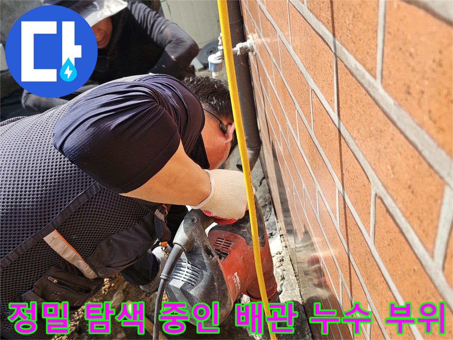 노란 가스 호스가 연결된-탐지기로 바닥 아래의 물샘 지점을 찾는 장면