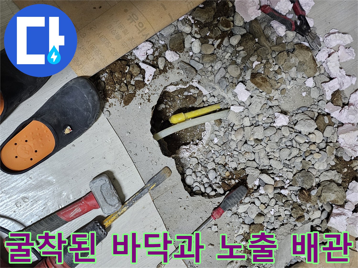 바닥을 깨서 드러난 파손된 수도 라인과 공구들
