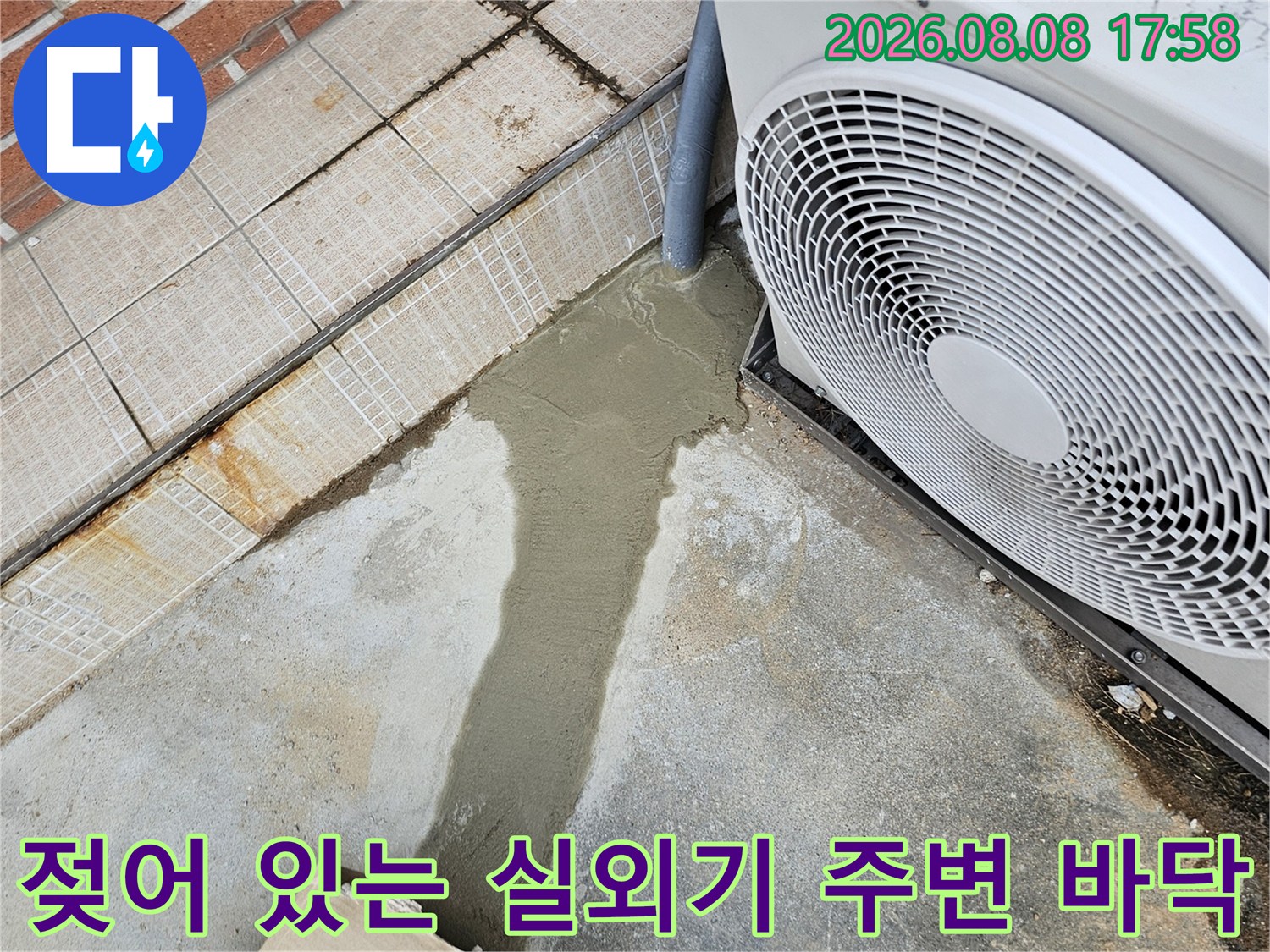 에어컨 실외기 아래쪽 물기가 번져 있는 콘크리트 지면