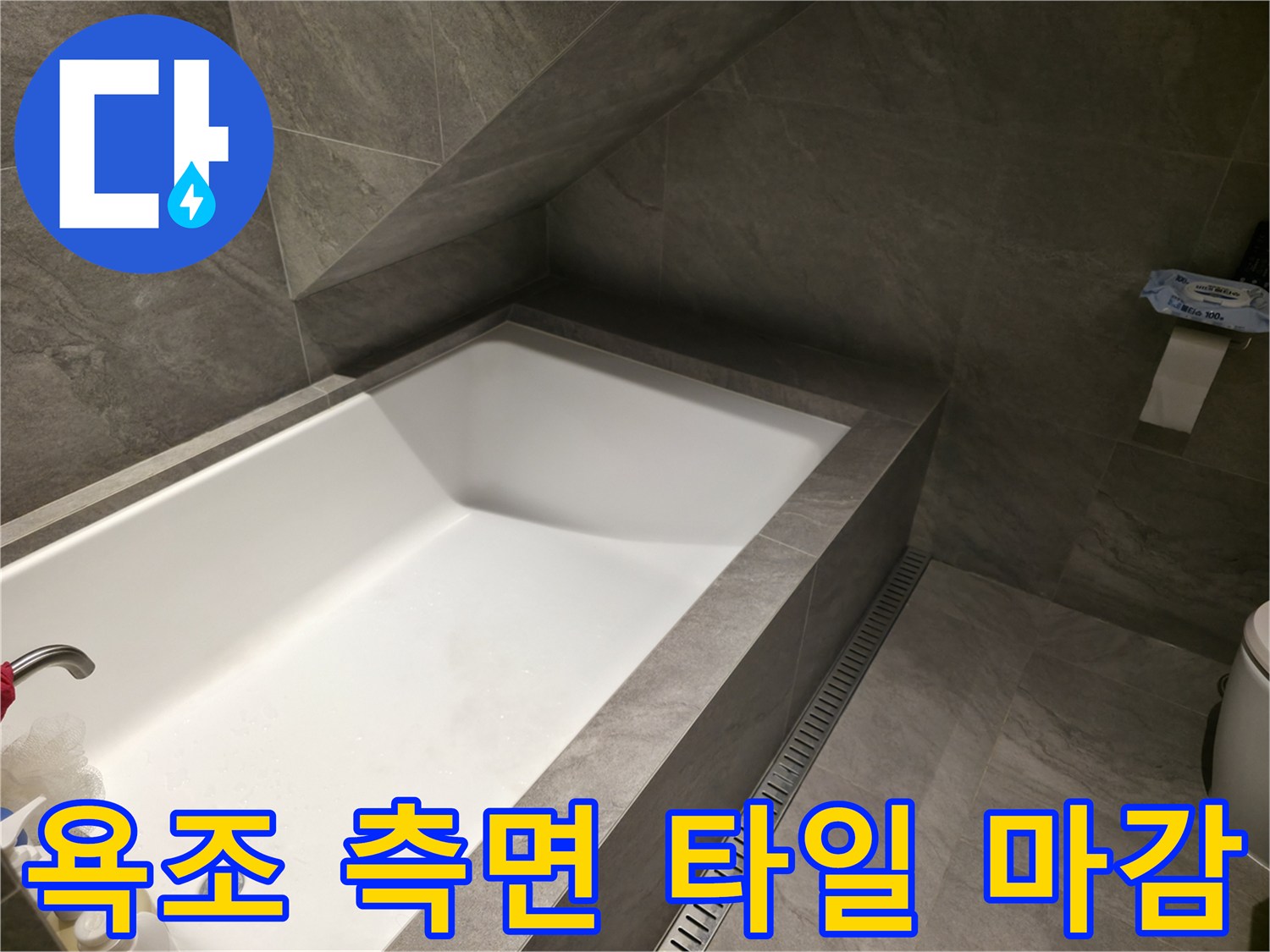 회색 대리석 패턴 타일로 마감된 욕조 옆면 모습입니다.