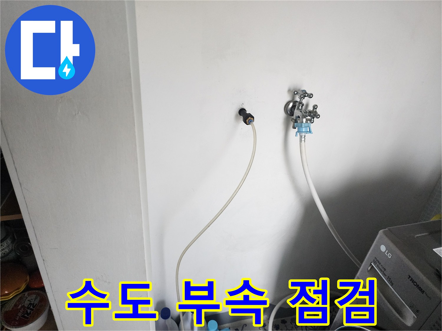 화장실 벽면에 설치된 금속 재질의 수전과 연결 호스