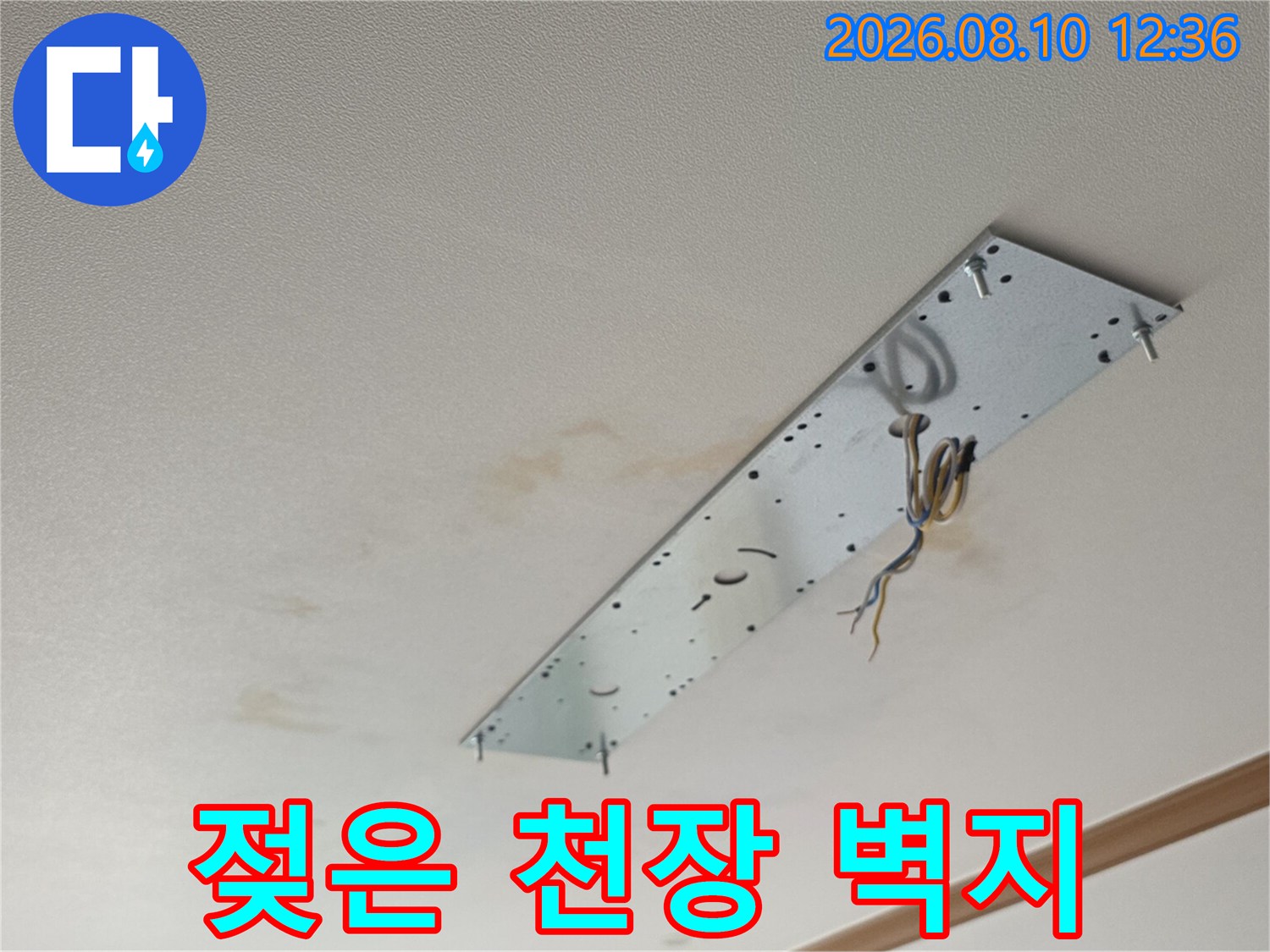 누수로 인해 변색된 천장 벽지와 조명 부위