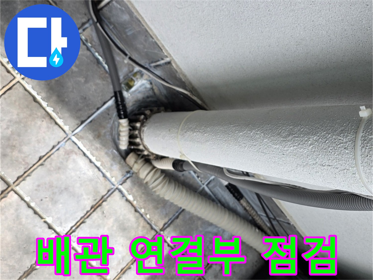 하얀색 외부 배관과 연결된 호스 및 타일 접합 부위