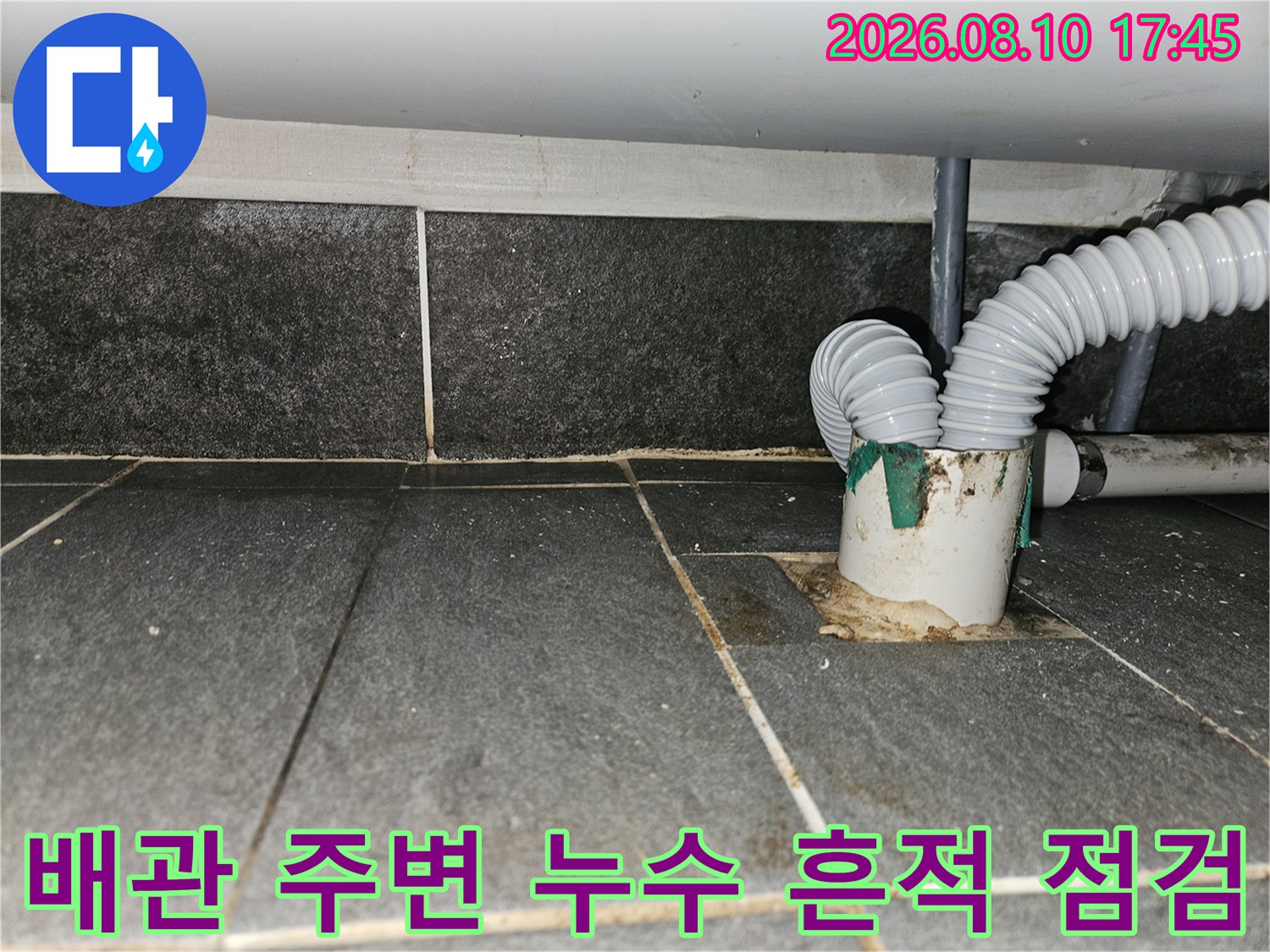 배관 연결 부위의 오염된 상태와 타일 틈새 물 고임 현상입니다.