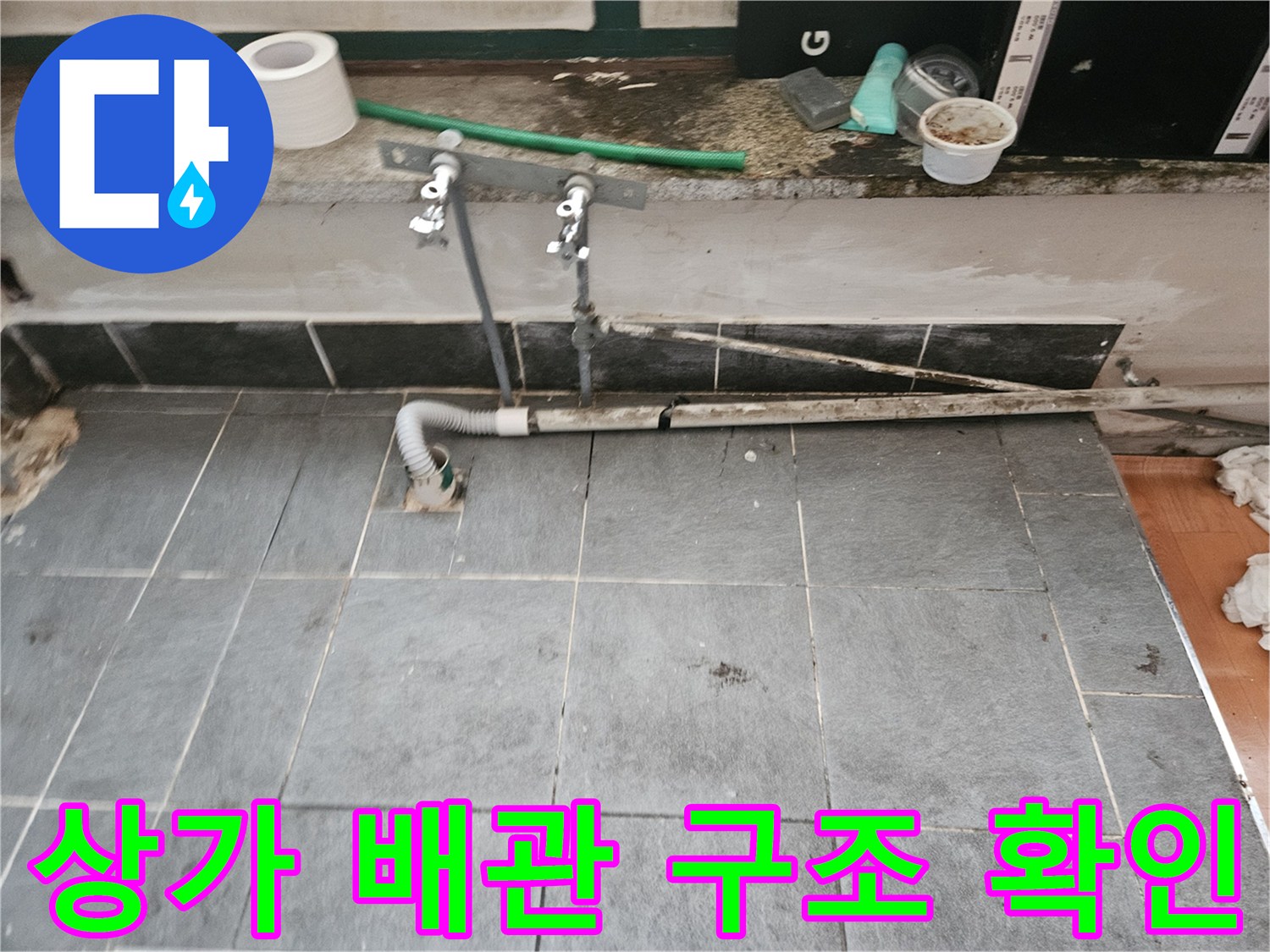 회색-타일-바닥에-설치된-금속-밸브와-배관