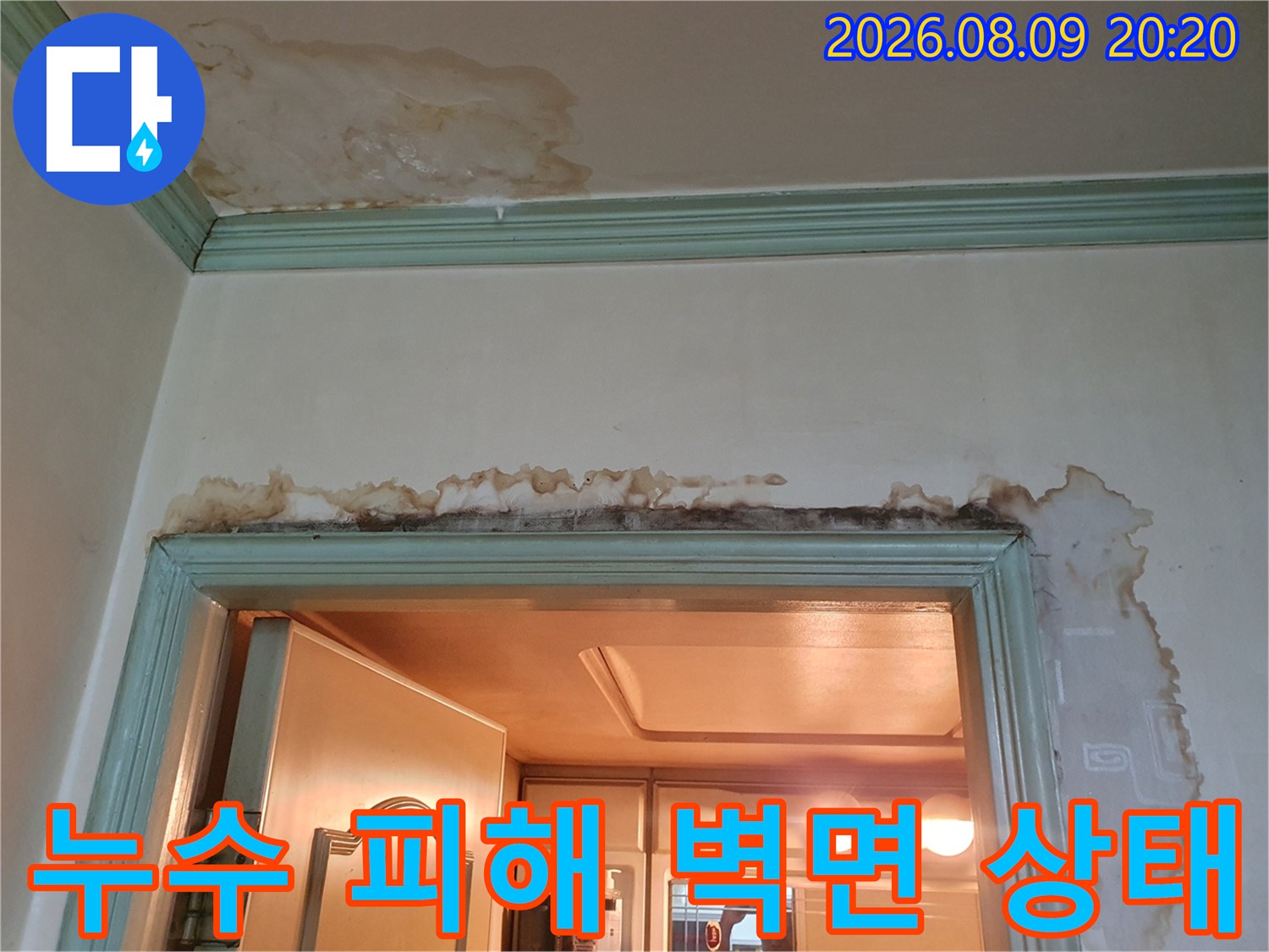 문틀 상단부-물기가 스며들어 짙은 얼룩이 남은 천장과 벽면