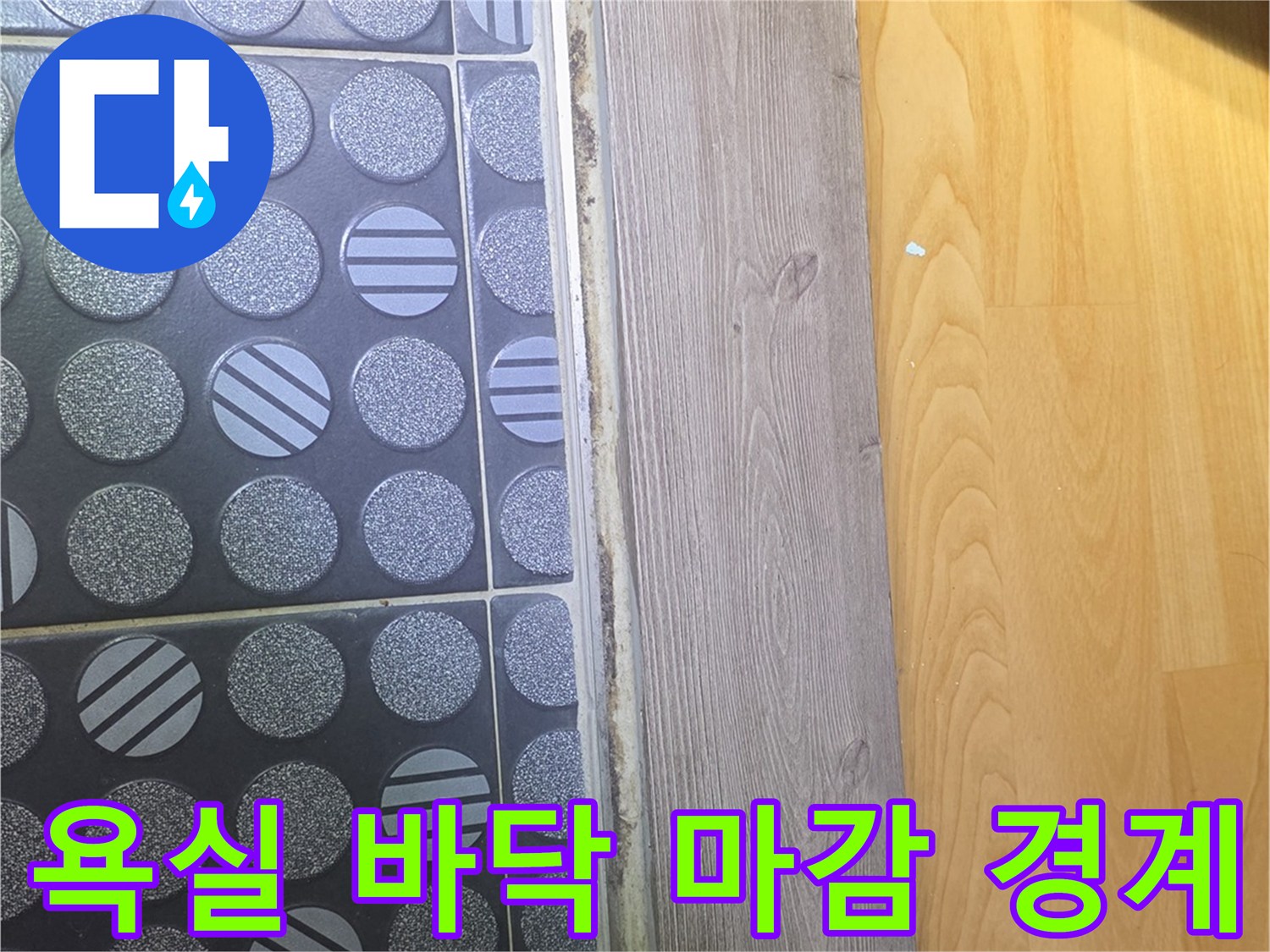 욕실 입구의 패턴 타일과 나무 판재 접합부 근접 촬영