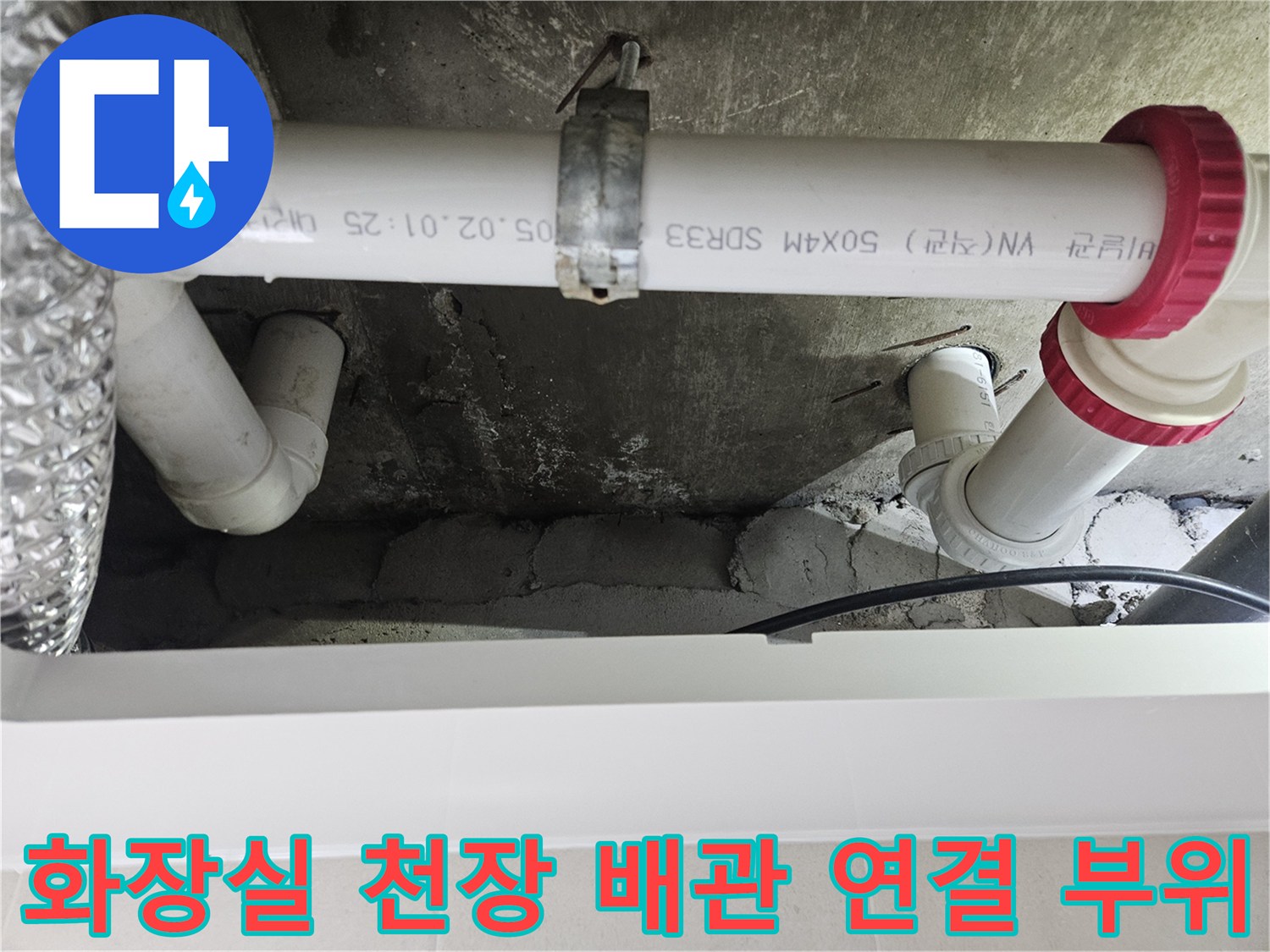 천장에 고정된-흰색 PVC 하수 파이프와 붉은색 소켓의 체결 모습