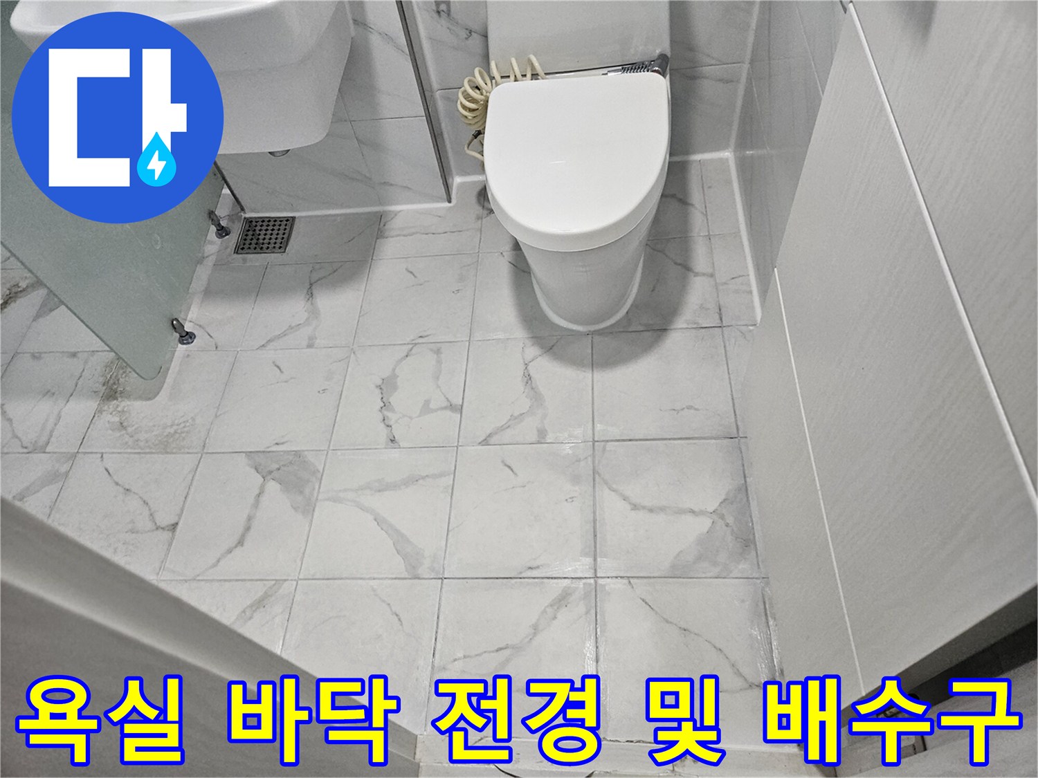 화장실-바닥의-흰색 타일과-금속제 배수구 유가-양변기 모습